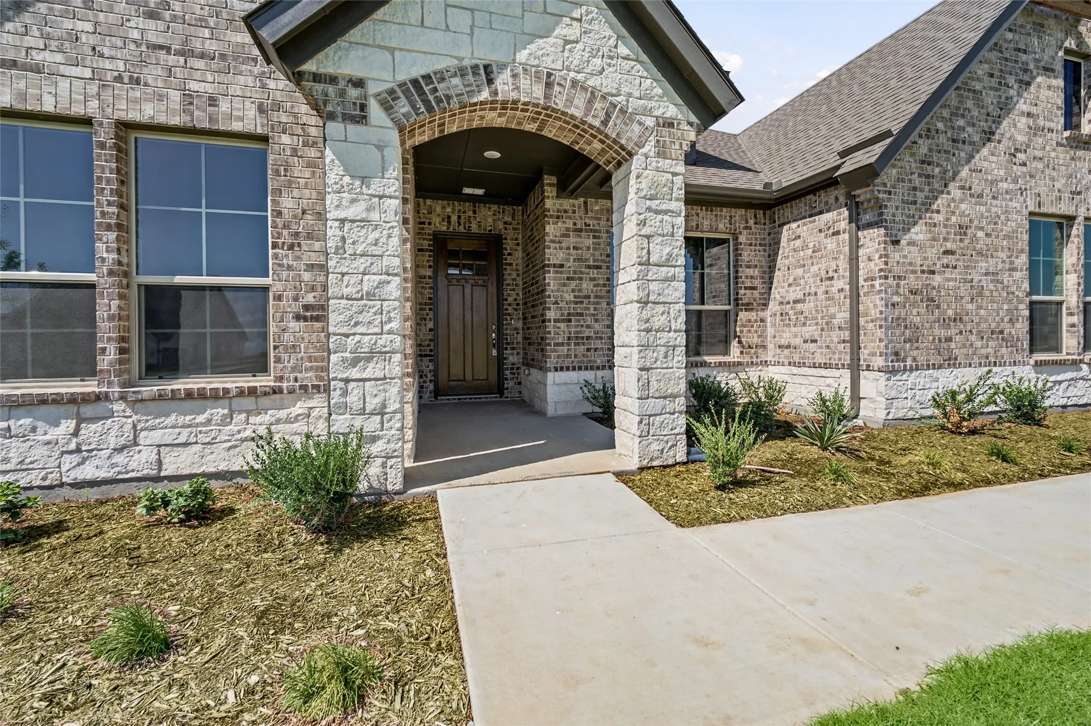 Brick and stone exterior with an arched entryway
