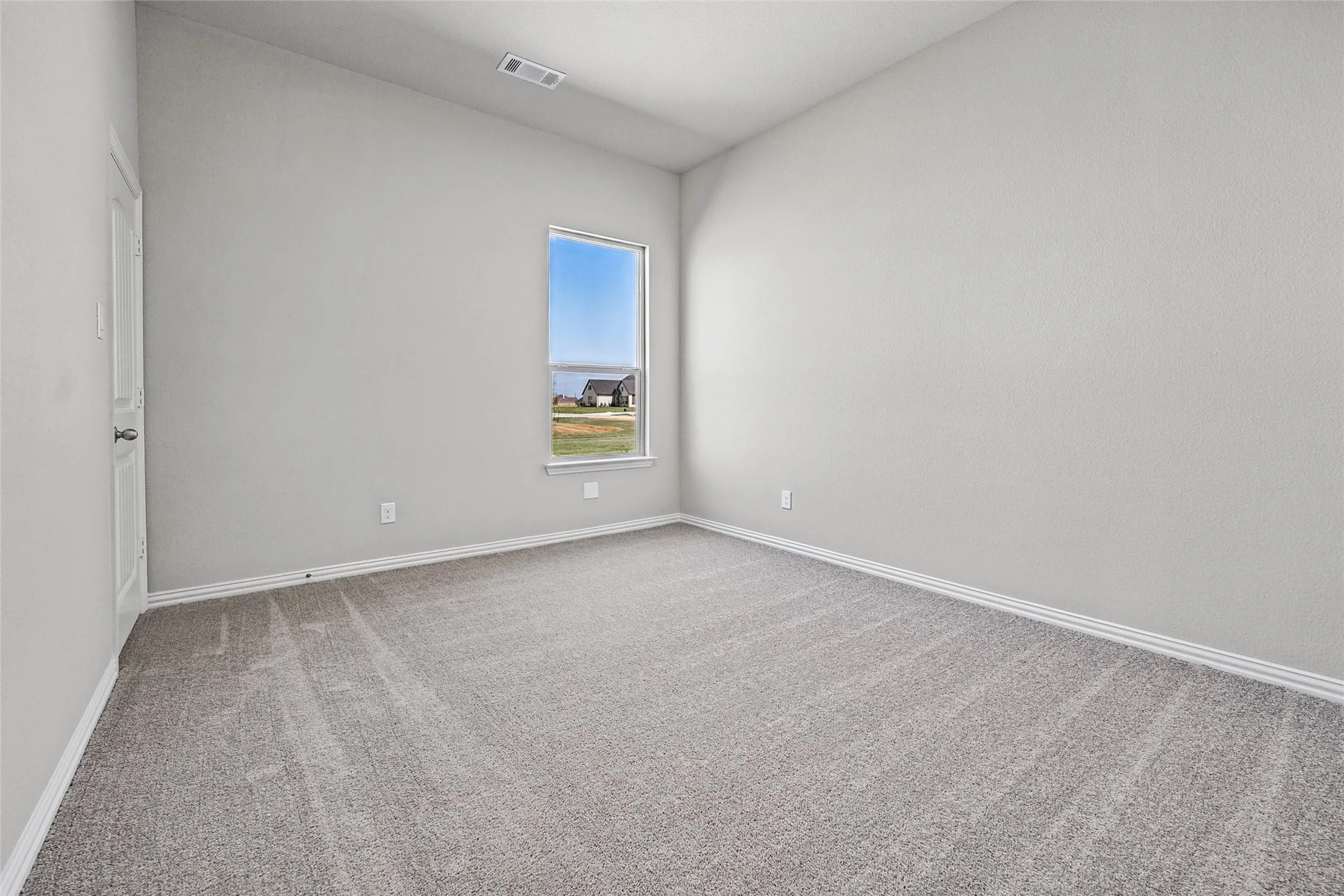Vaulted ceiling, neutral wall paint, carpet flooring, single window, white trim
