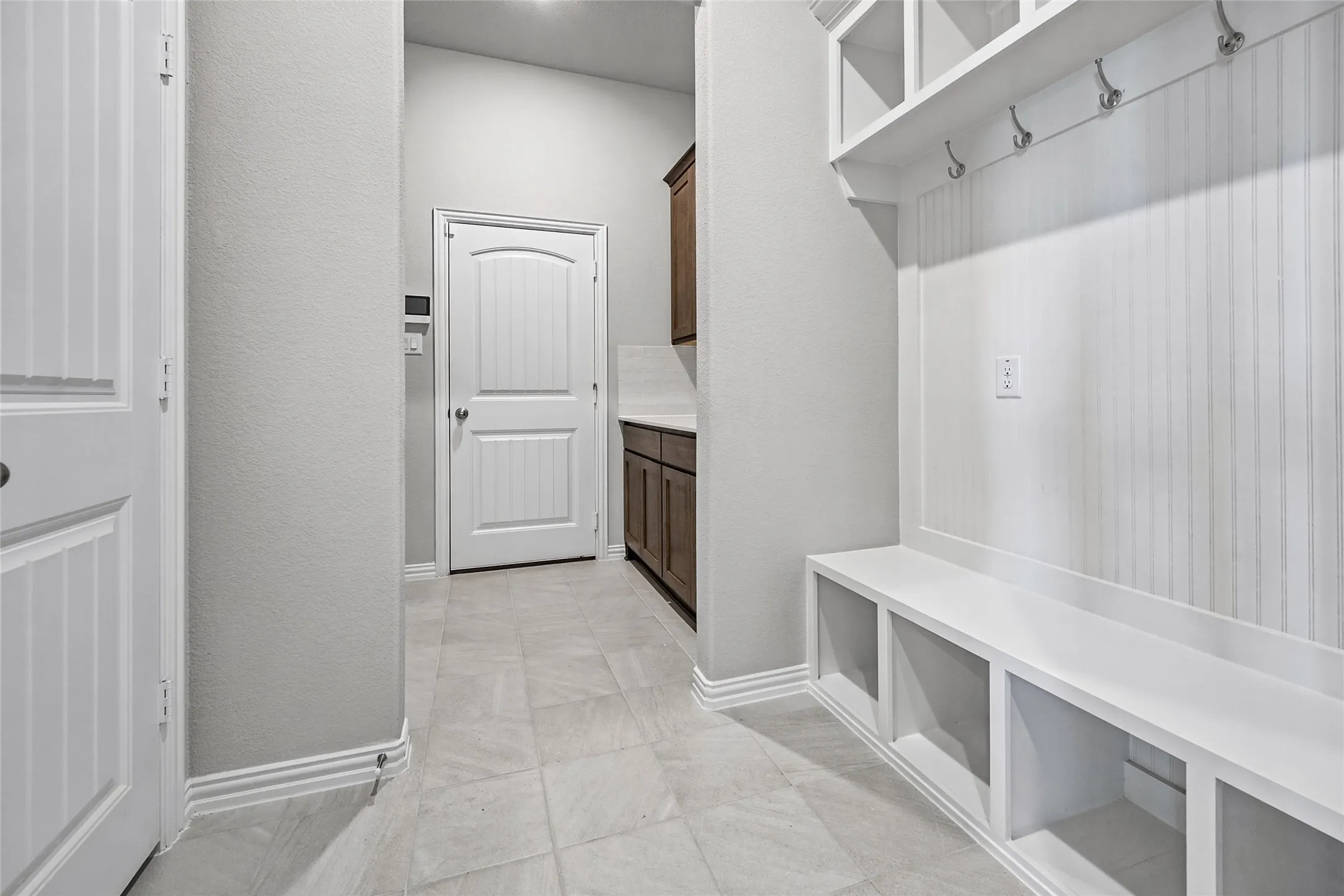 Built-in storage bench with overhead shelving and coat hooks