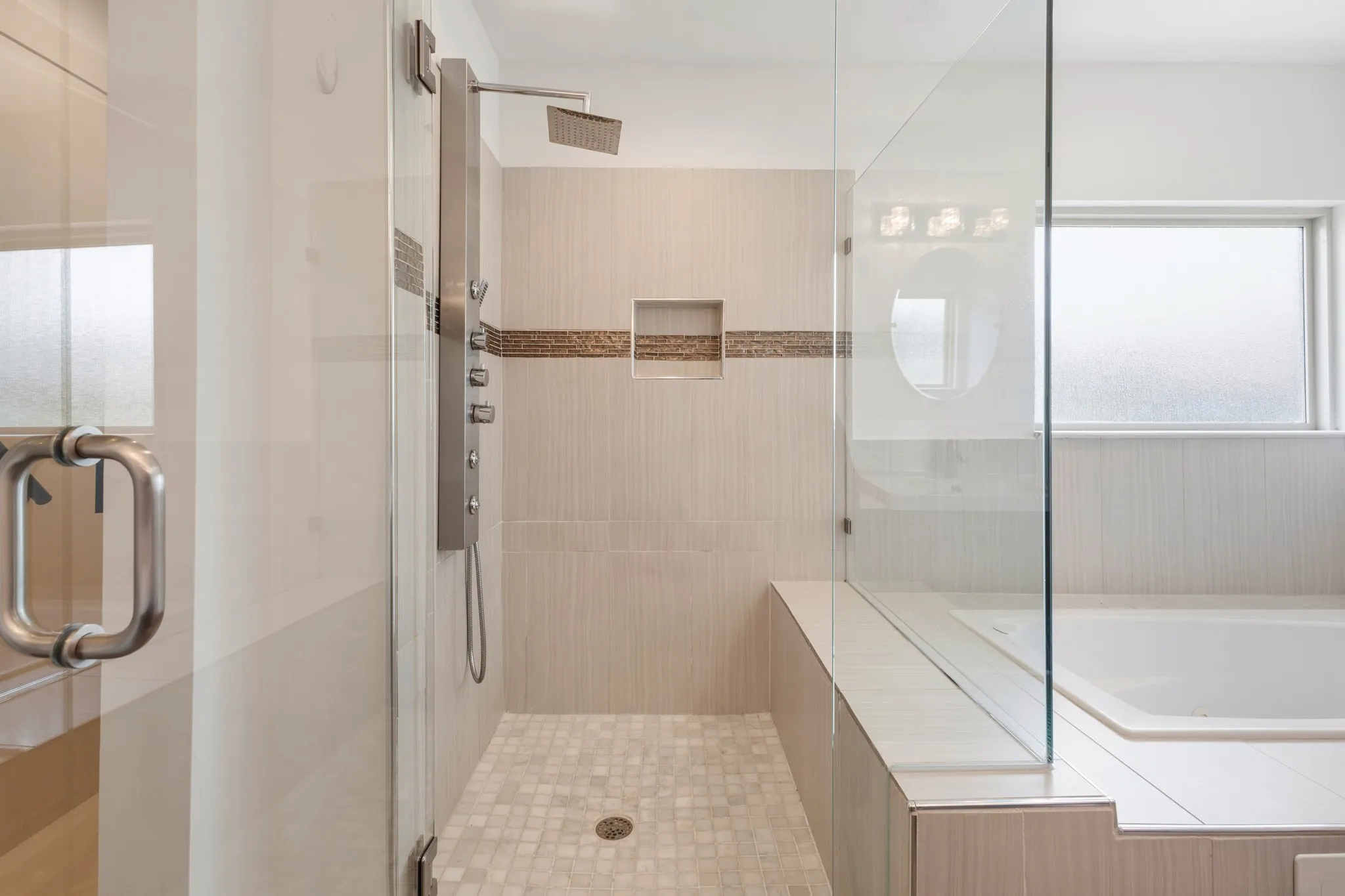 2nd shower enclosure with dark bronze hardware, featuring a built-in bench and a bronze showerhead