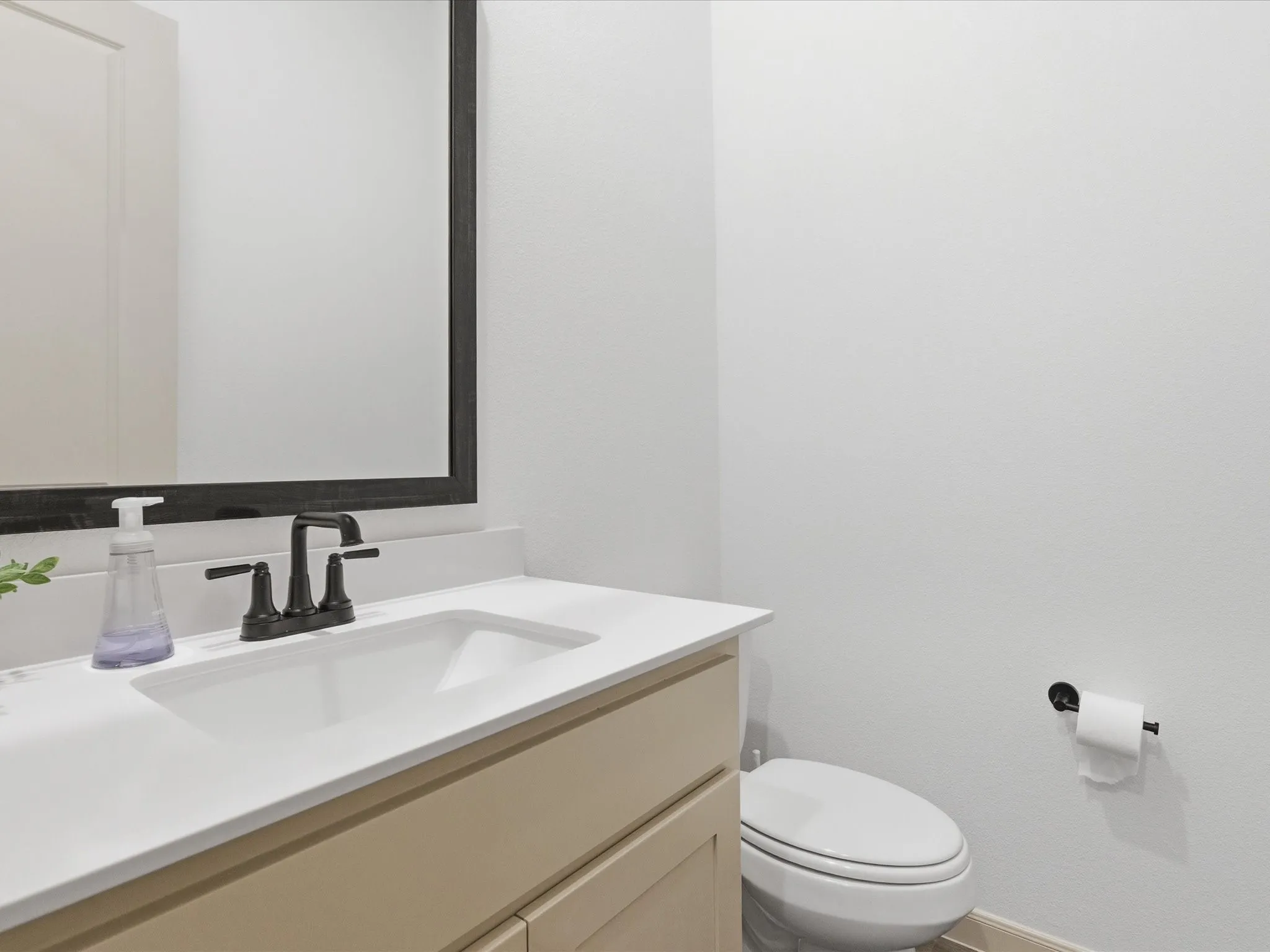 Modern vanity featuring a beige cabinet, white countertop, and integrated sink