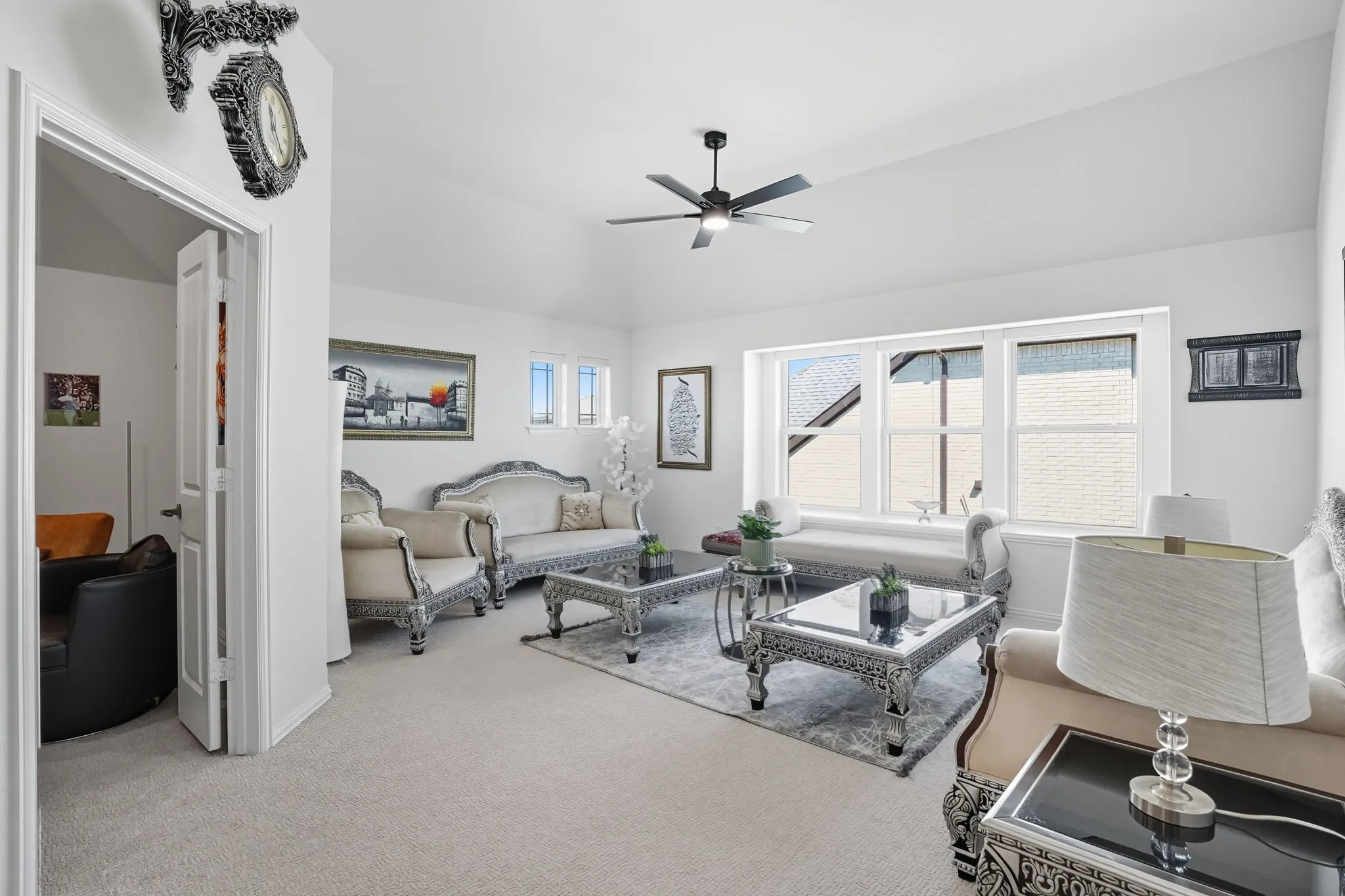 Carpeted living area featuring a vaulted ceiling and a ceiling fan