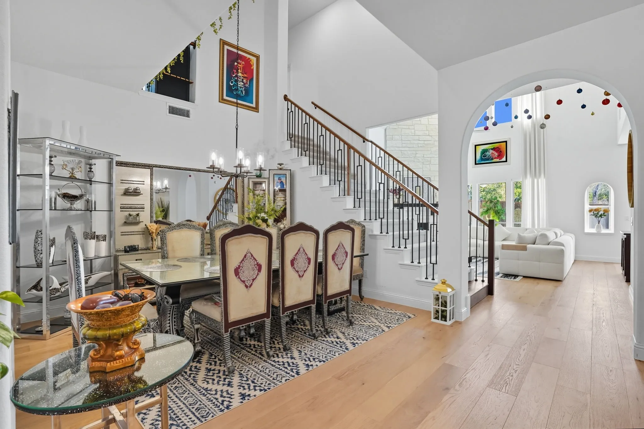 Vaulted ceilings highlight the grand staircase featuring wood handrails and black iron balusters