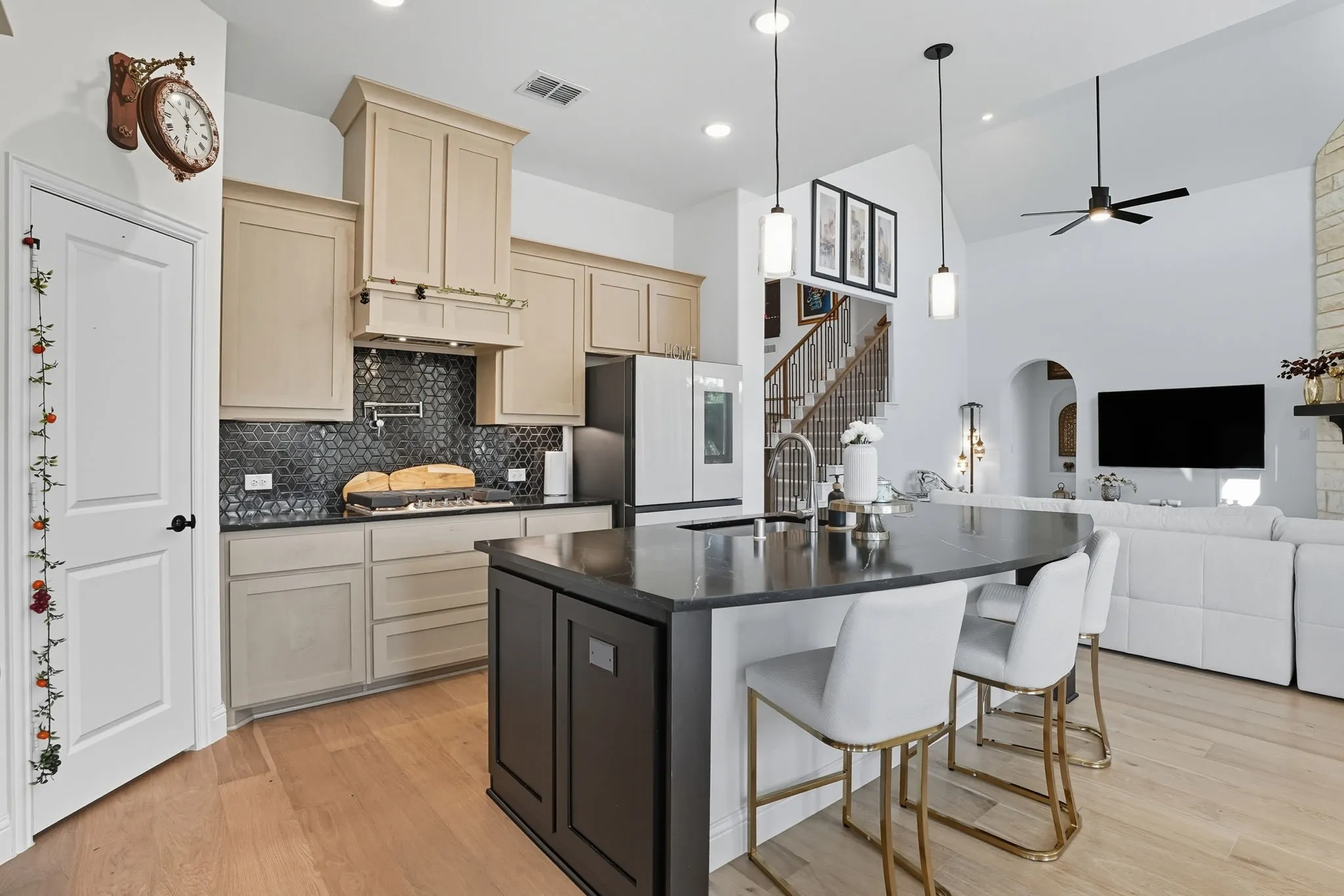 Spacious kitchen with wood-finish flooring, light-toned cabinetry, and dark backsplash
