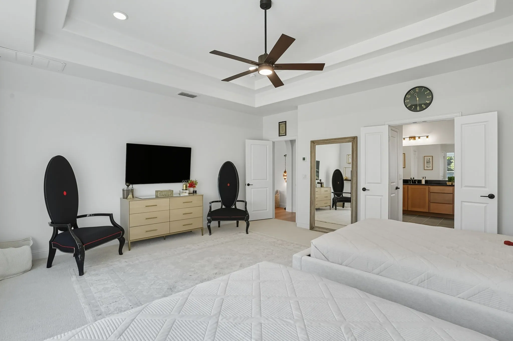 Spacious room with a tray ceiling and a ceiling fan