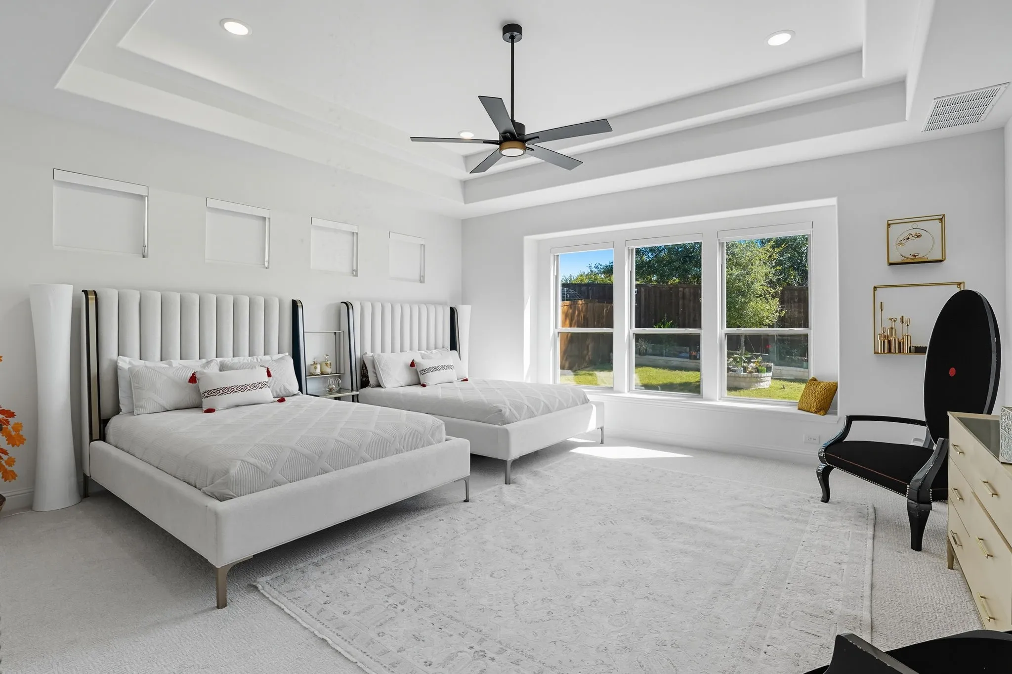 Spacious room featuring a tray ceiling with recessed lighting and a ceiling fan
