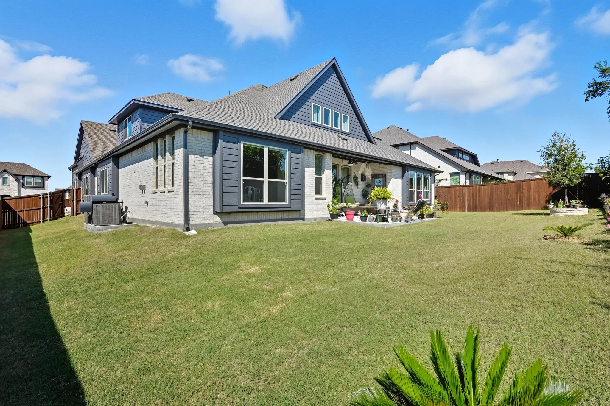 Expansive backyard featuring a manicured lawn, a covered patio, and a privacy fence