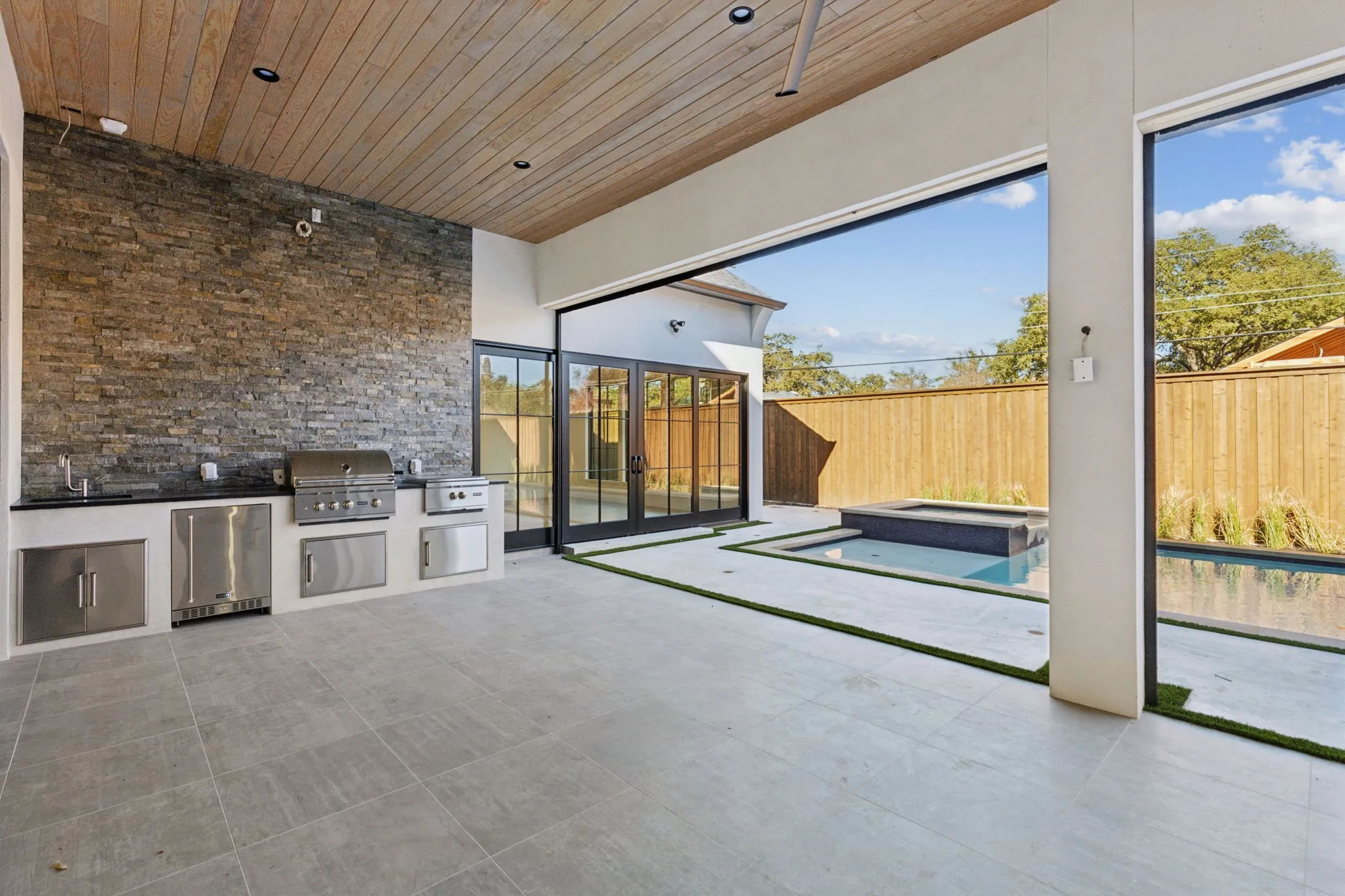 Fenced backyard featuring area for grilling, a patio area, and a pool with connected hot tub