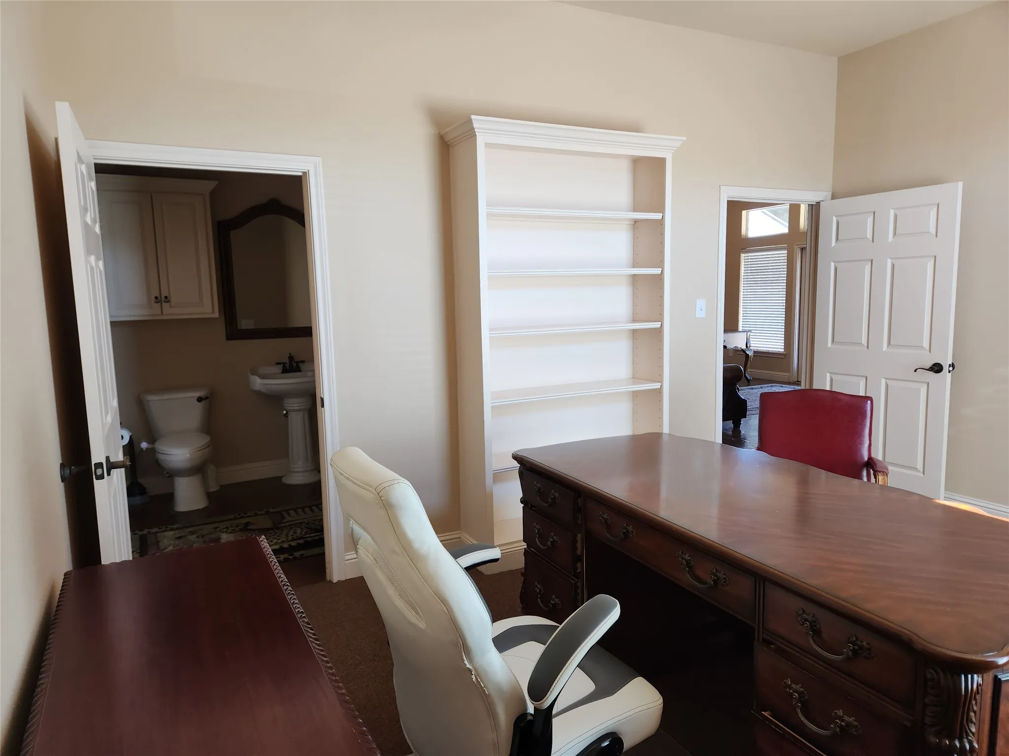 Room featuring neutral wall tones, built-in shelving, and carpet flooring