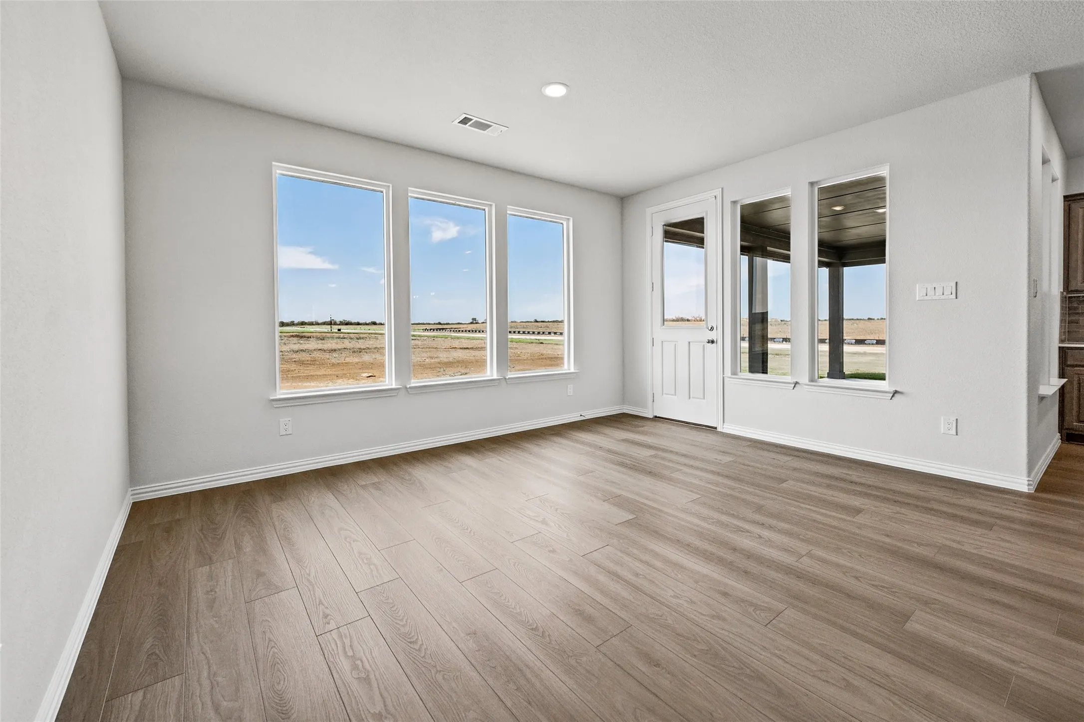 Bright corner room flooded with natural light through triple-pane windows overlooking expansive grounds