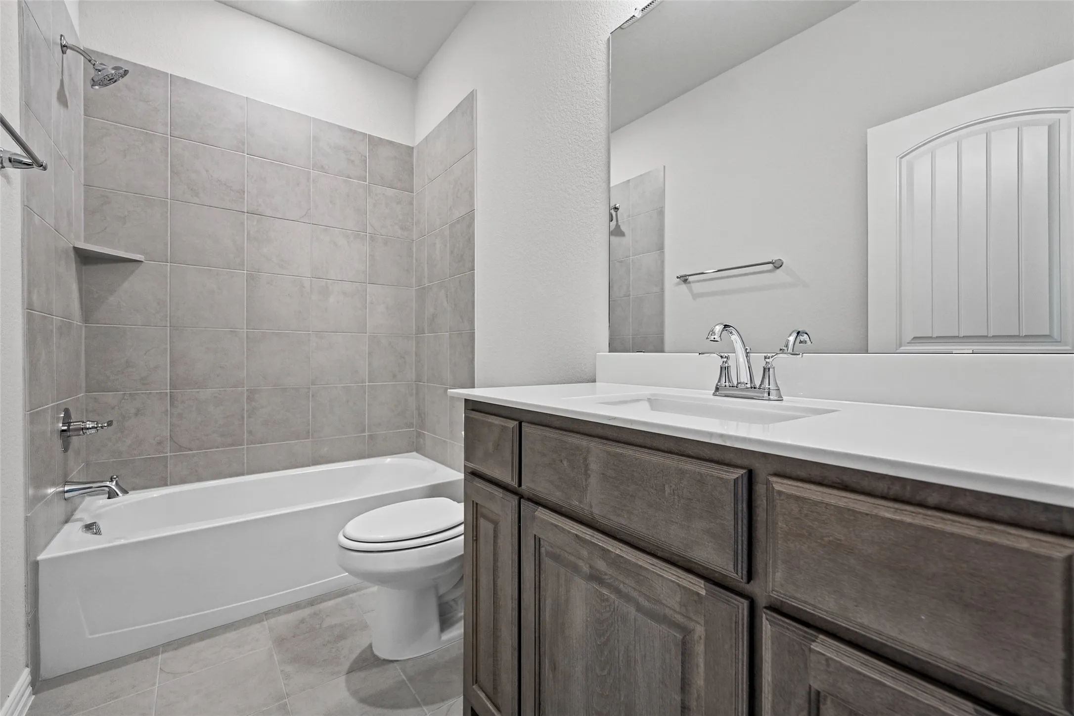 Wood-finish vanity with a white countertop and integrated sink