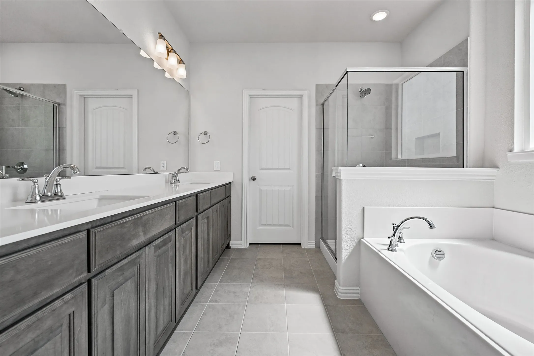 Dual vanity with light gray wood-finish cabinetry and white countertops