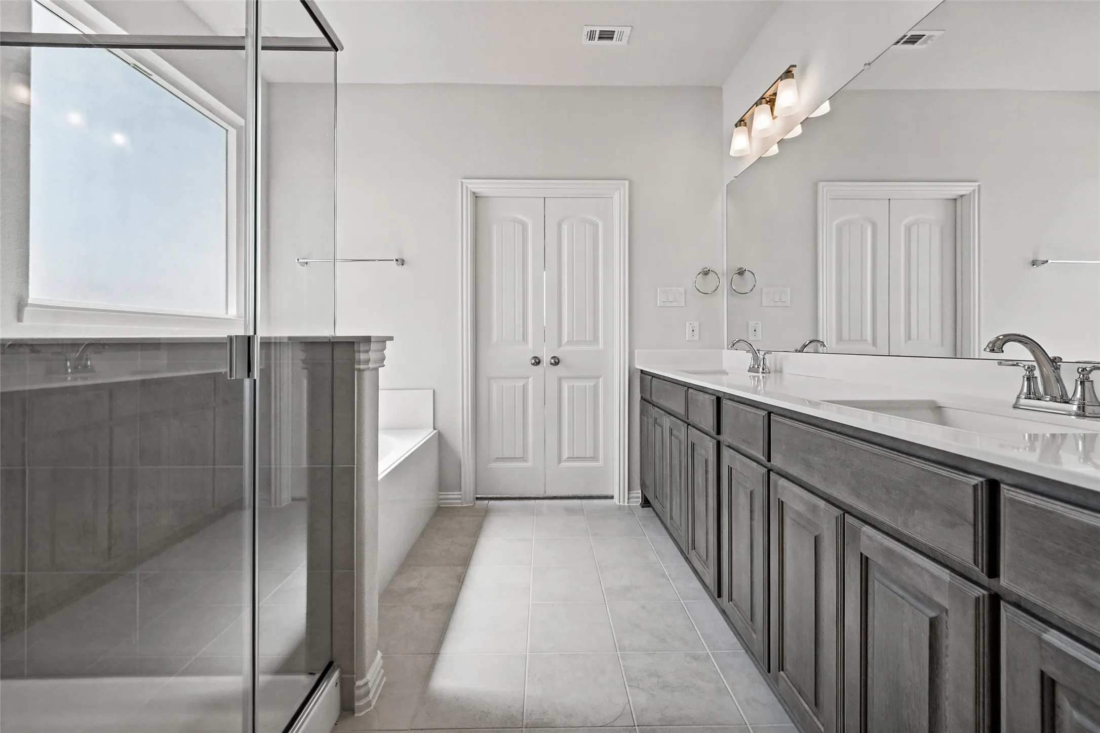 Dual vanity with white countertops, undermount sinks, and brushed nickel fixtures