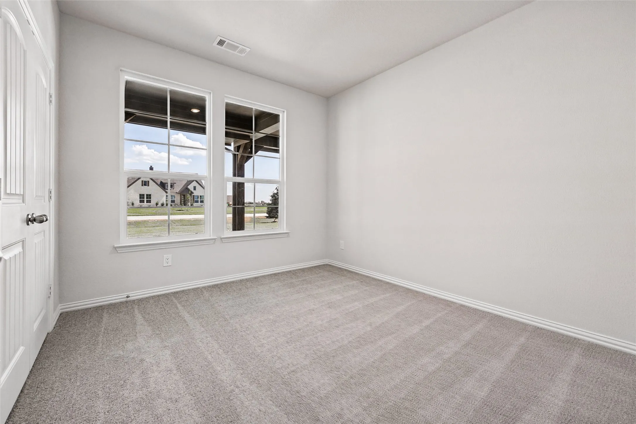 Neutral wall color, carpeted flooring, and a multi-pane window