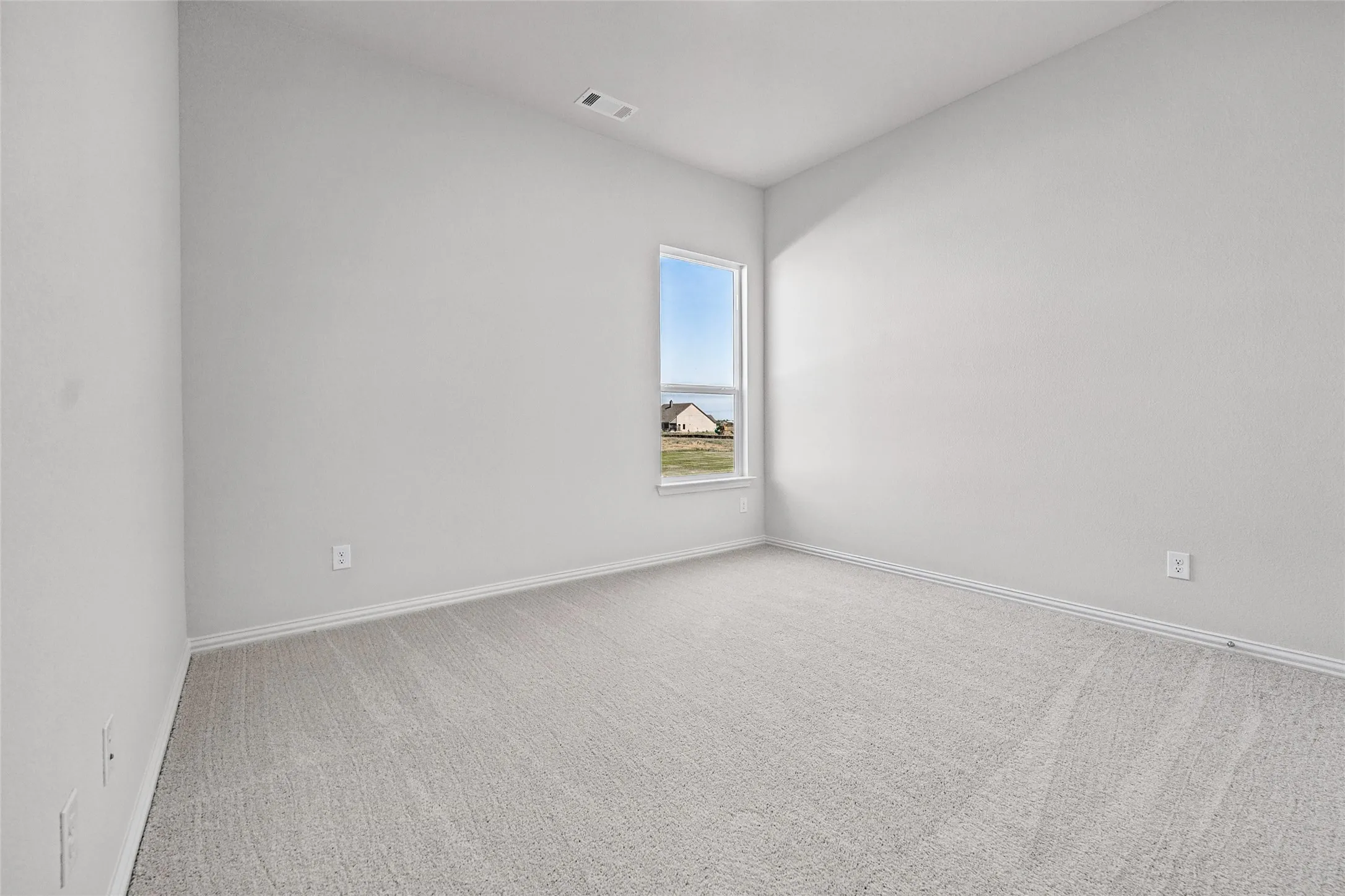 Neutral tone wall paint, light gray carpet flooring, single window, white window trim, and white baseboards