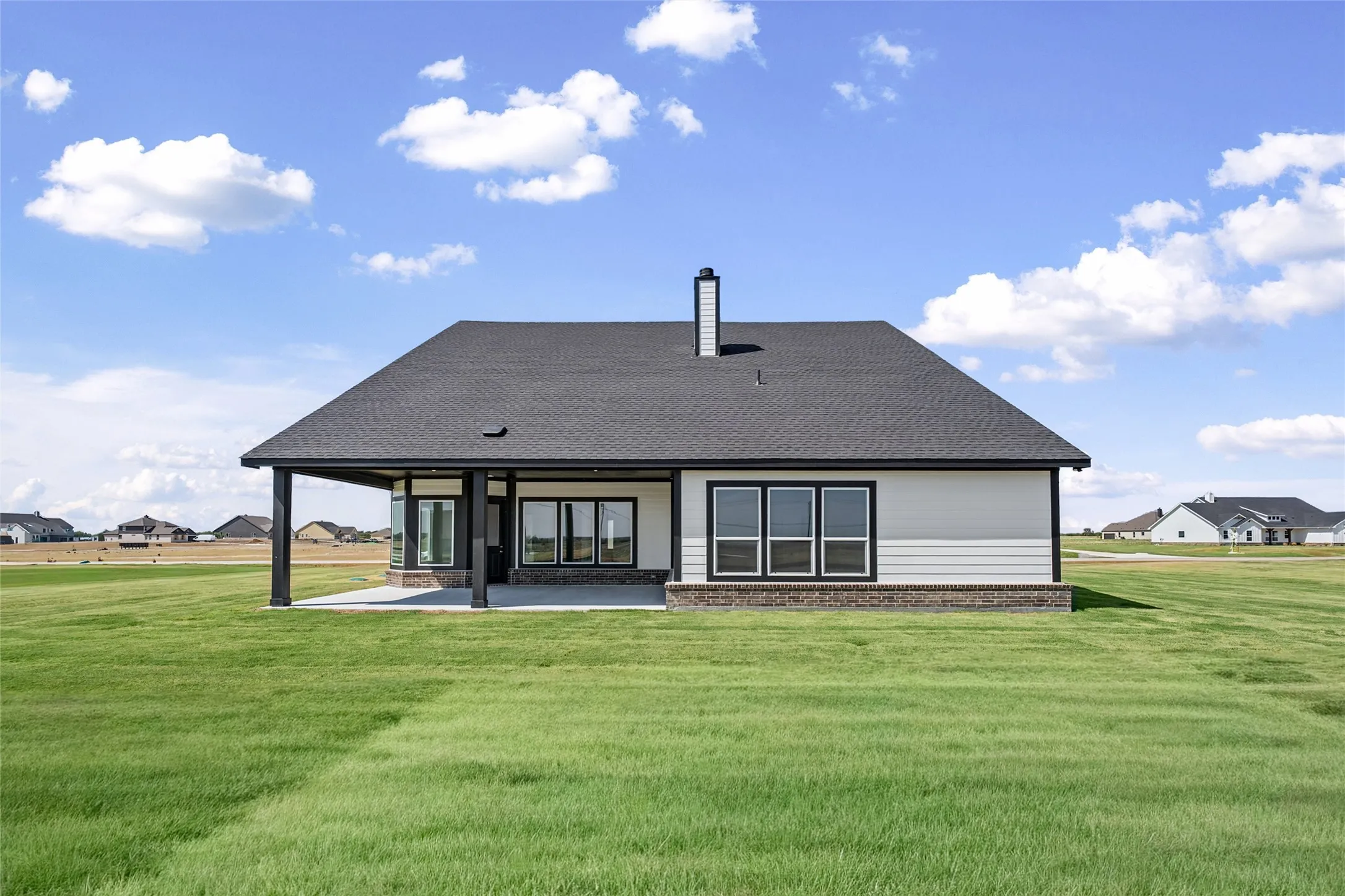 Expansive green lawn surrounds the property
