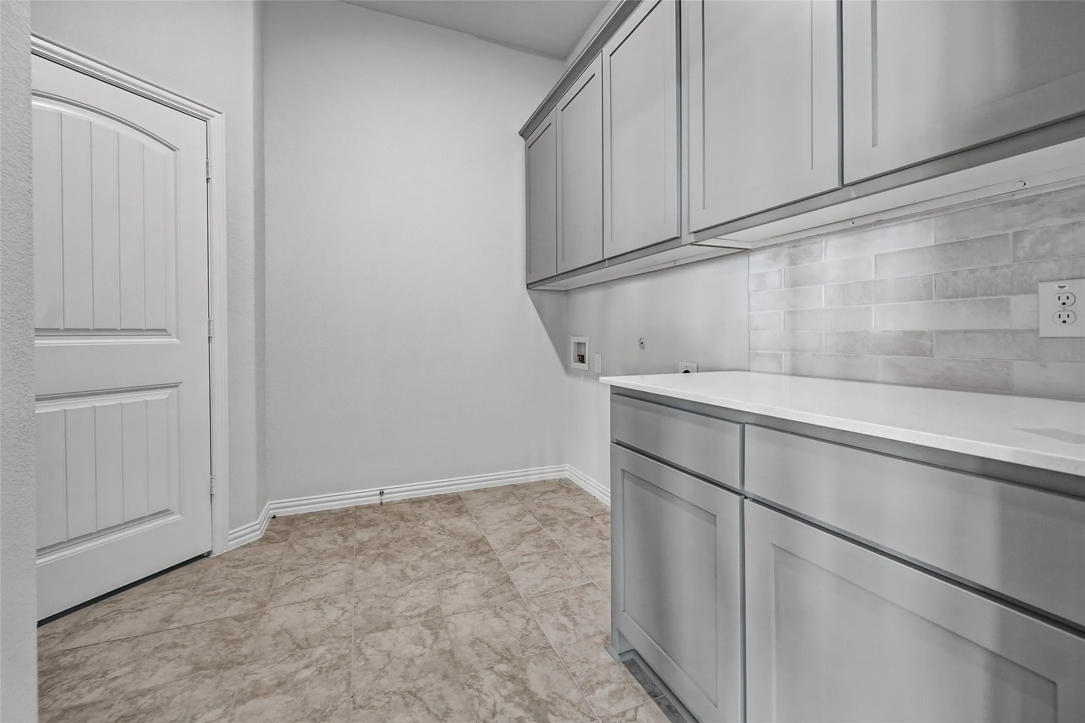 Built-in cabinetry with under-cabinet lighting, solid surface countertop, and a tiled backsplash