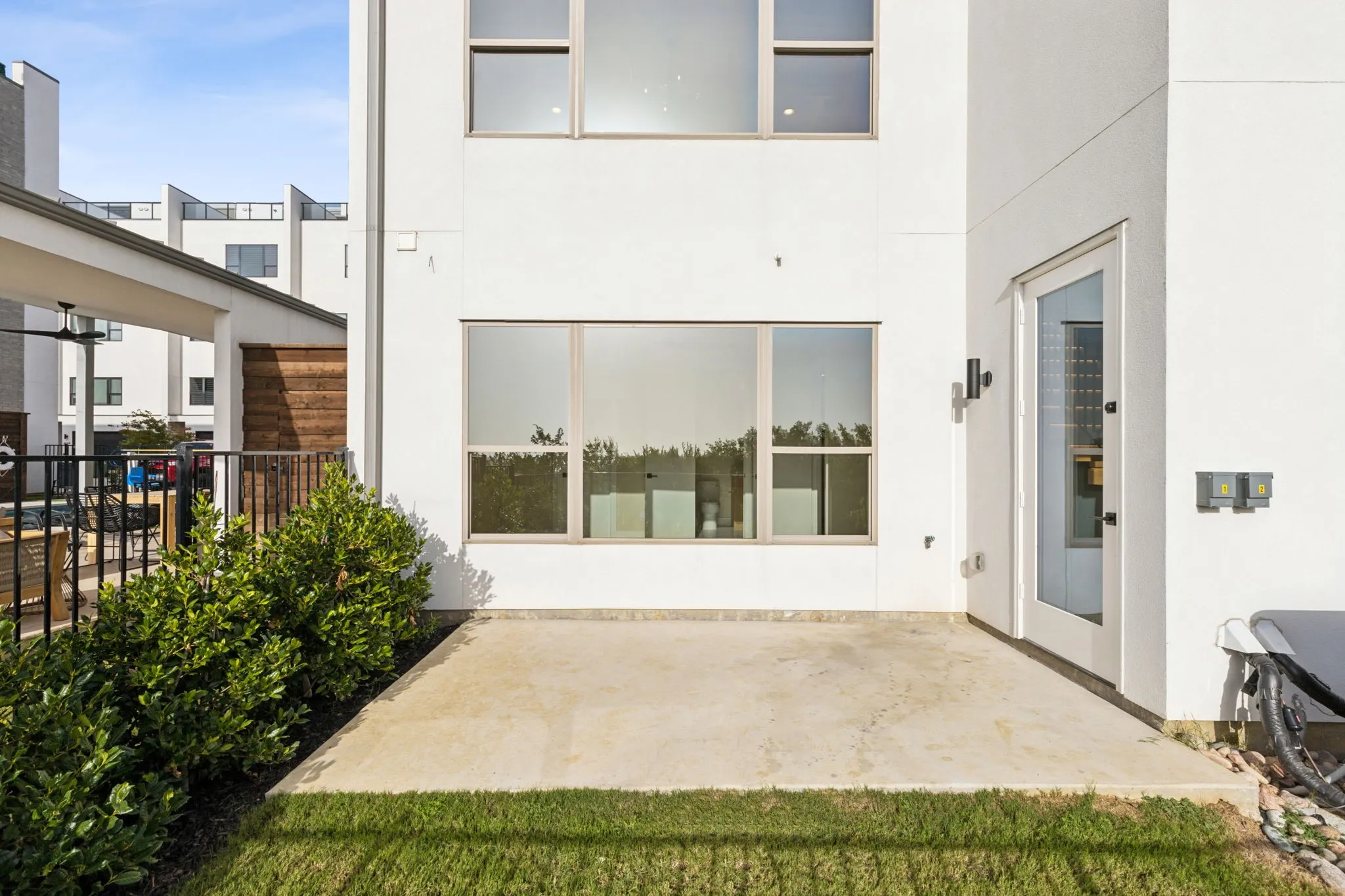 Rear view of property with stucco siding, fence, and a patio area