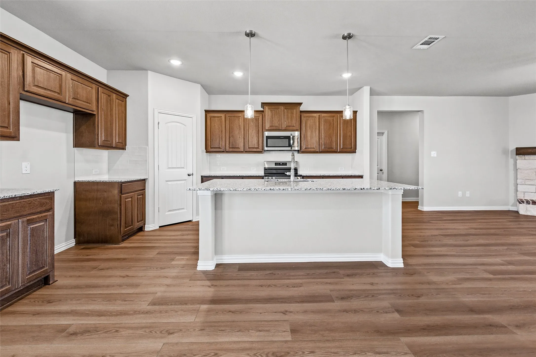 Kitchen with wood-finish flooring, recessed lighting, and a center island featuring pendant lights