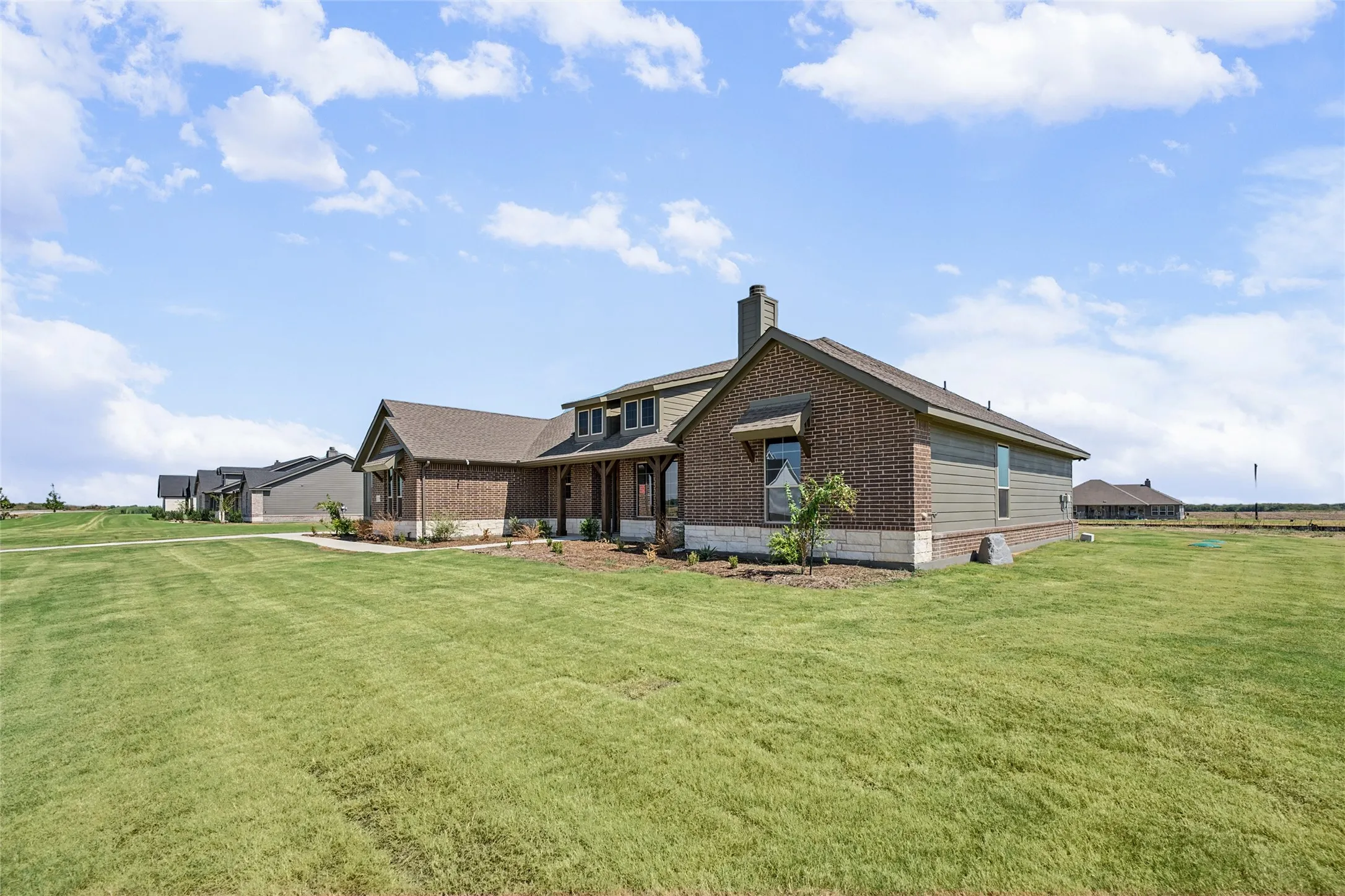 Brick and siding exterior with stone accents, covered entry, and pitched roof