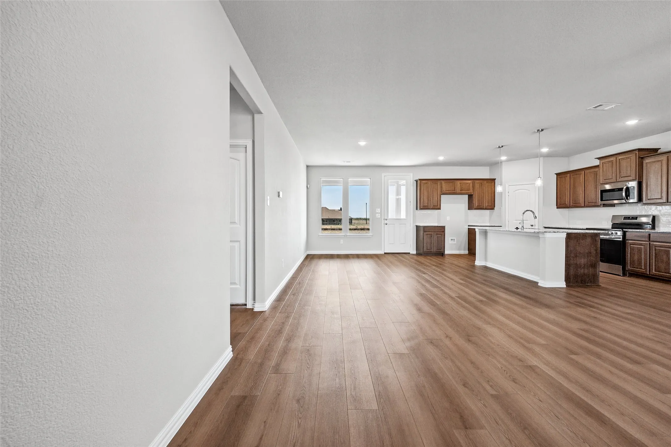 Open concept living area with wood-finish flooring