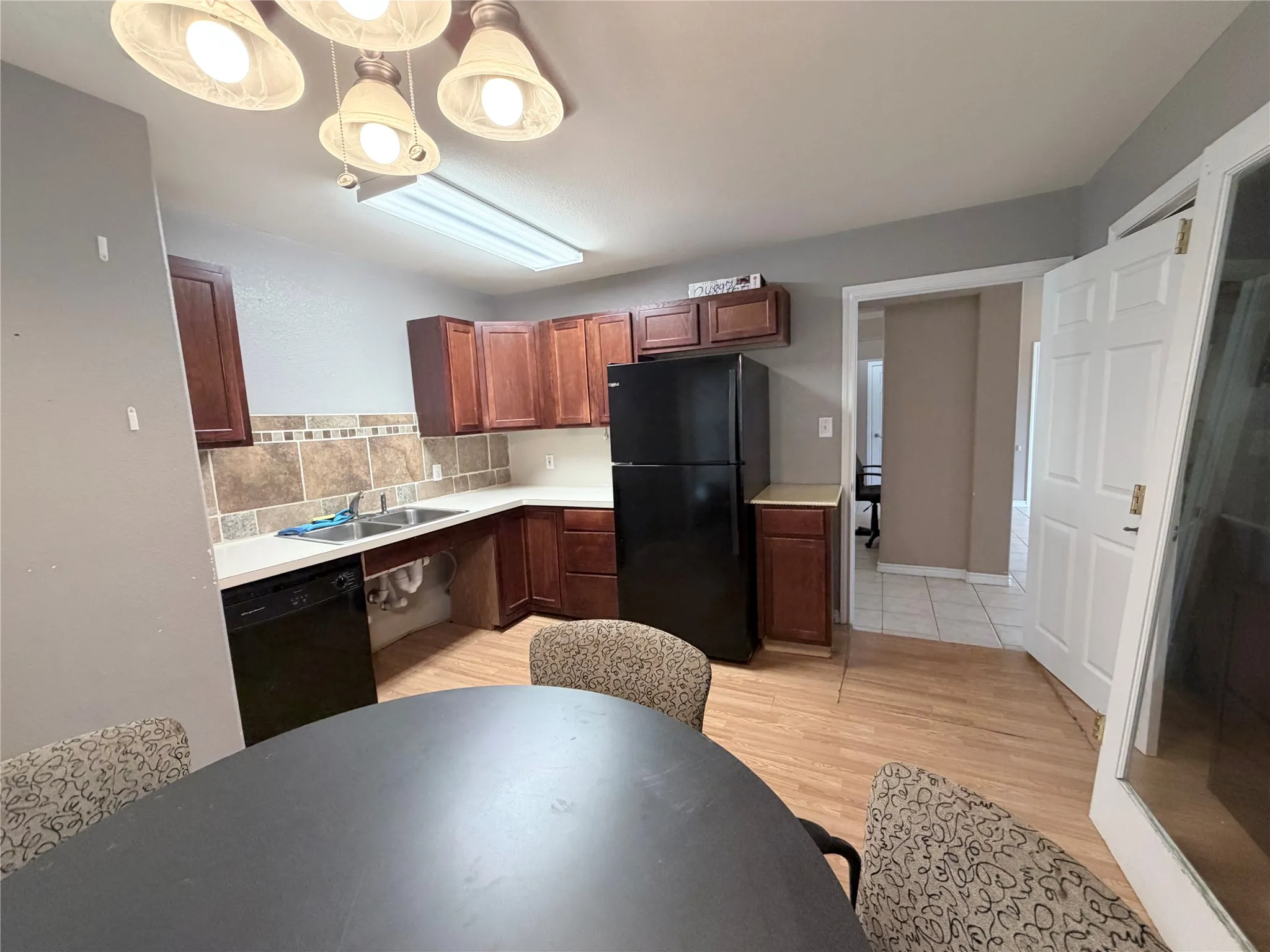 Kitchen featuring wood-finish flooring, dark wood cabinetry, and white countertops
