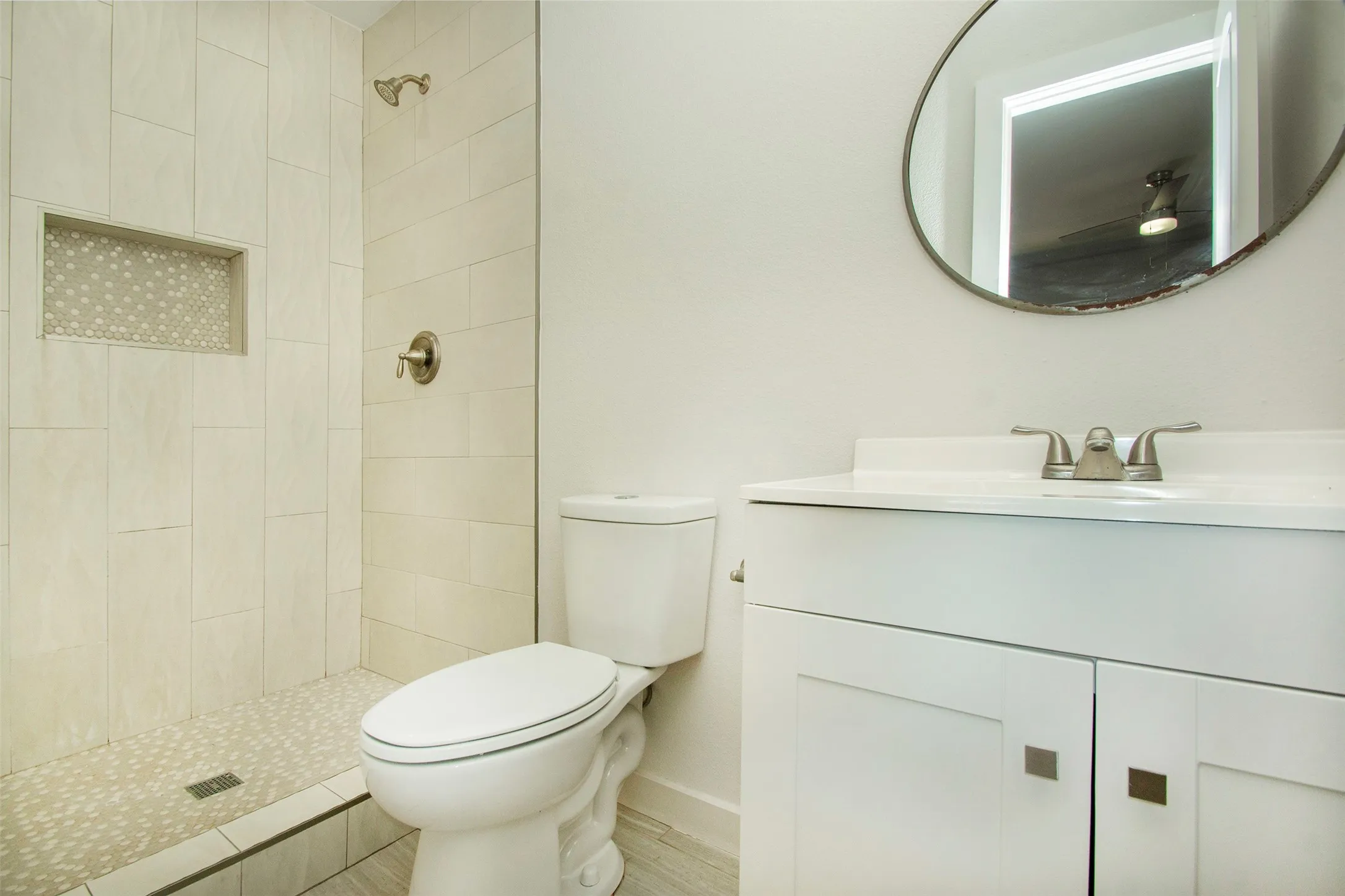Bathroom with vanity, toilet, and tiled shower