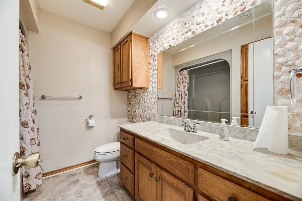 Bathroom vanity featuring a light-colored countertop with an integrated sink and chrome faucet