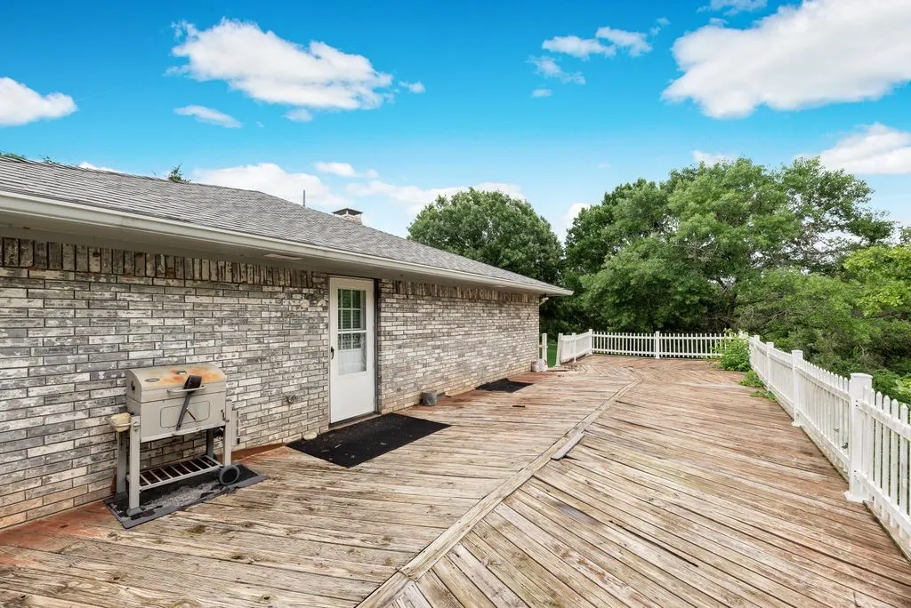 Expansive wood deck with white picket railing, featuring direct exterior access