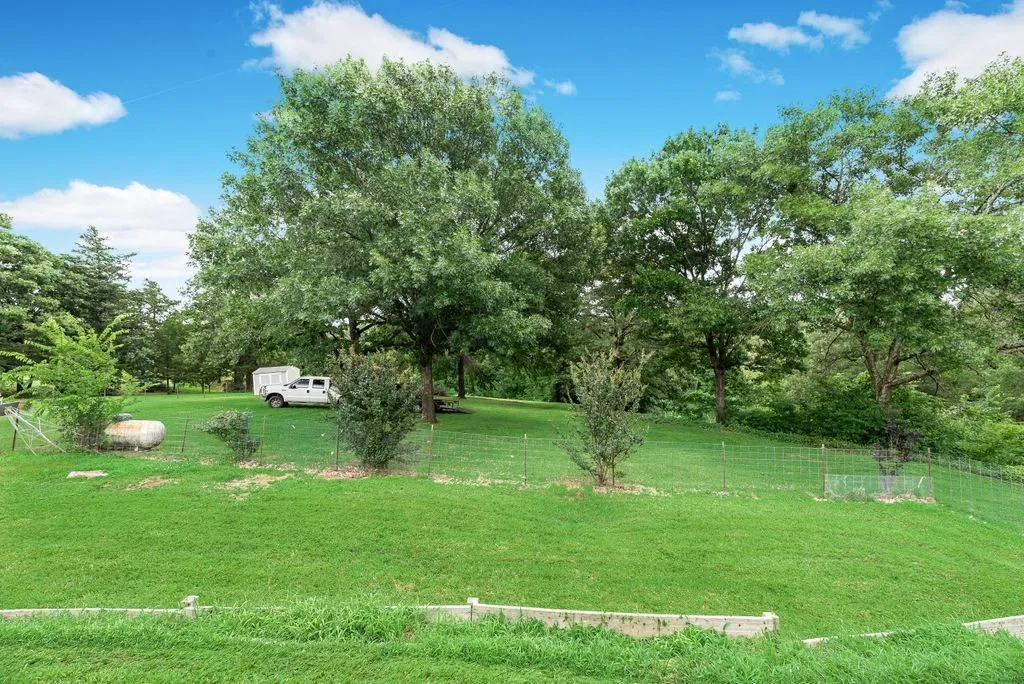 Expansive green lawn featuring mature trees and established landscaping