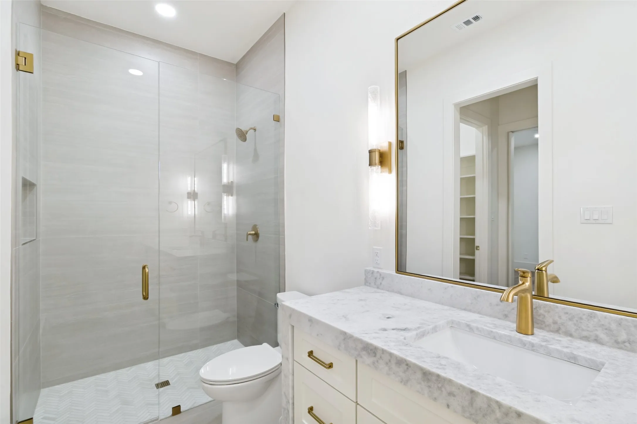 Bathroom featuring a glass-enclosed shower with light-toned wall tiling and hexagonal floor tiles