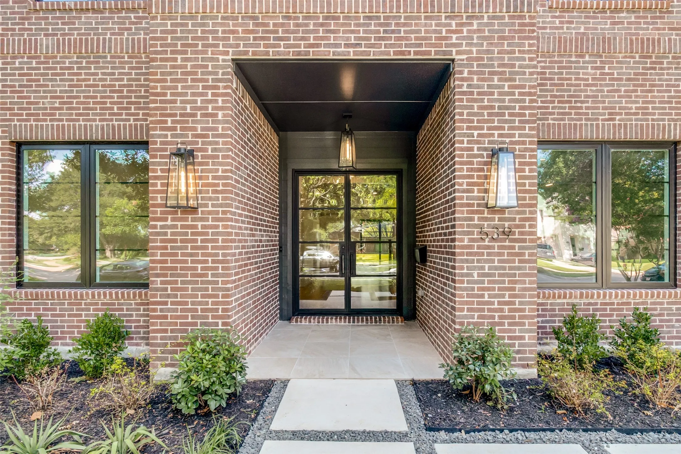 Brick facade with dark-framed windows and a prominent entry