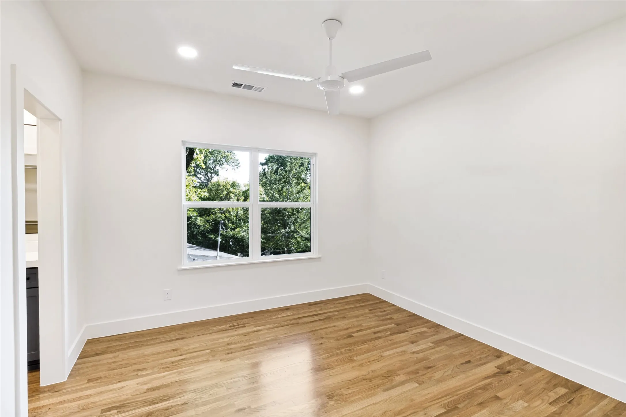 Room featuring wood-finish flooring, a contemporary ceiling fan, and recessed lighting