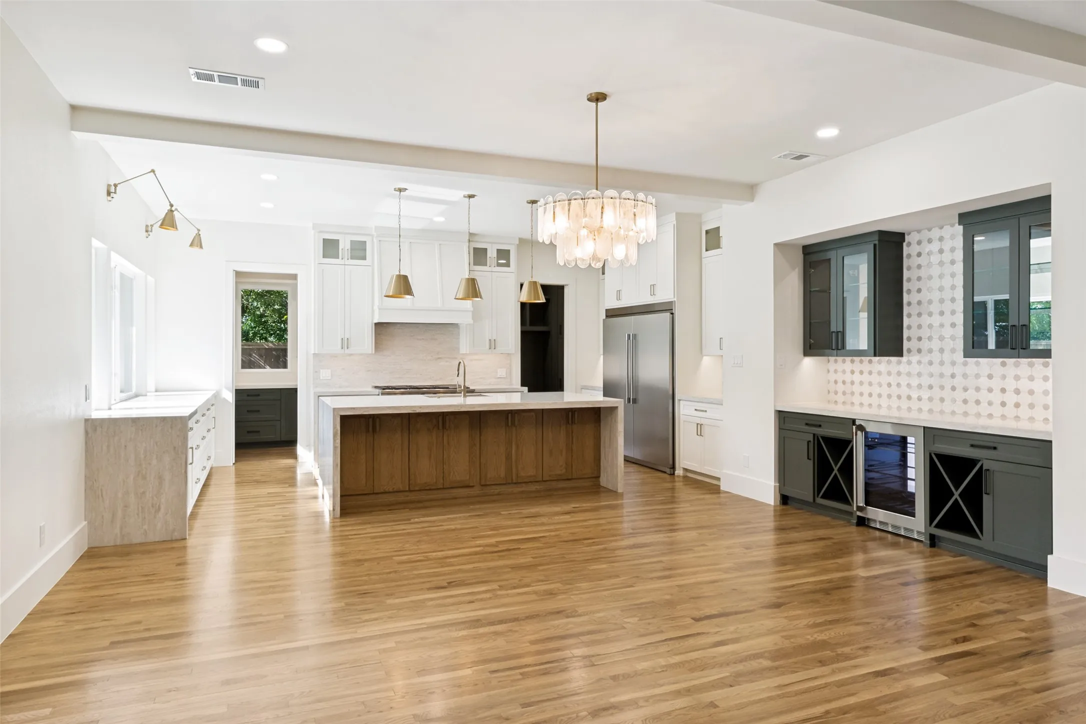 Expansive kitchen and dining area featuring light wood-finish flooring