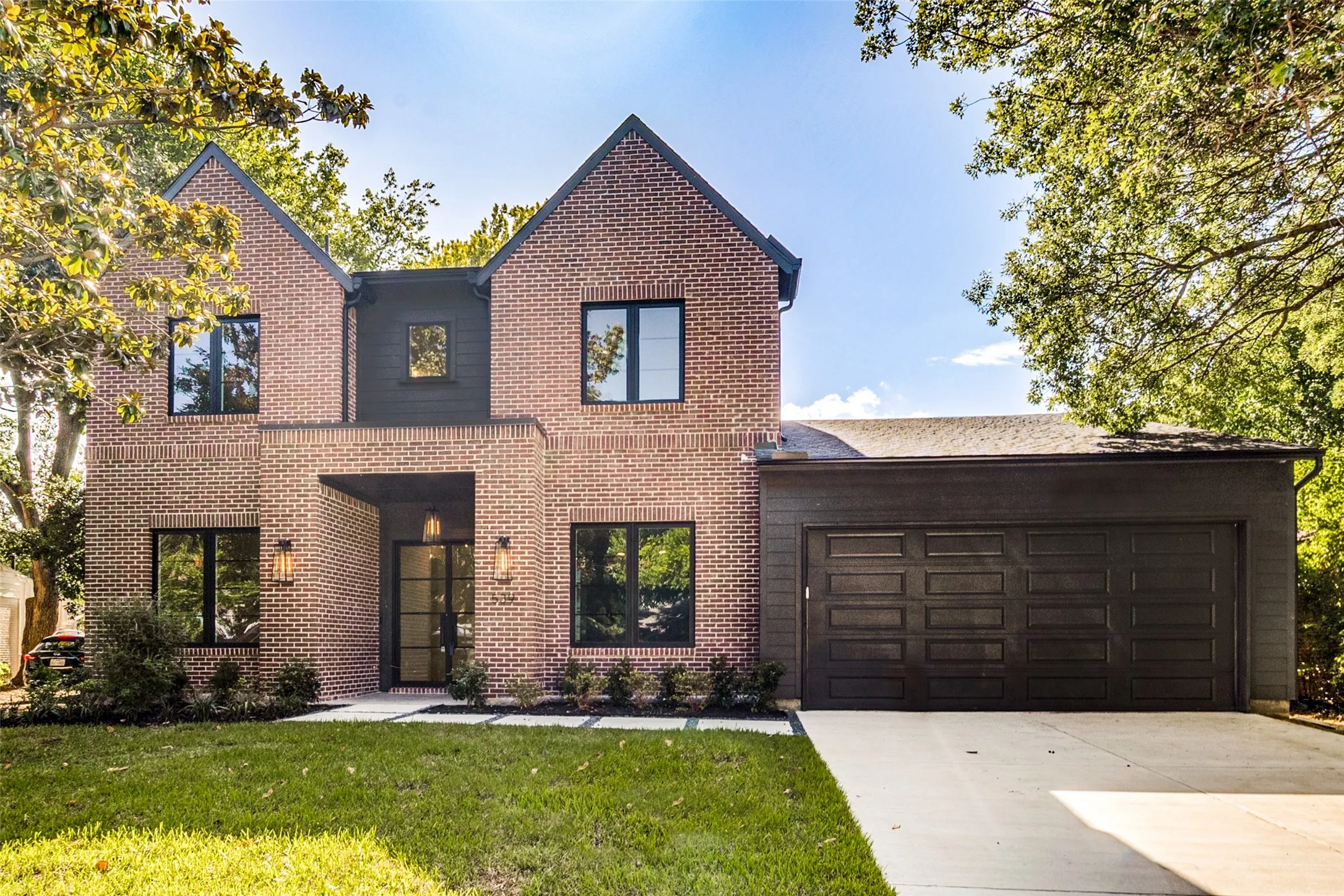 Contemporary brick facade featuring dark framed windows and a prominent entryway