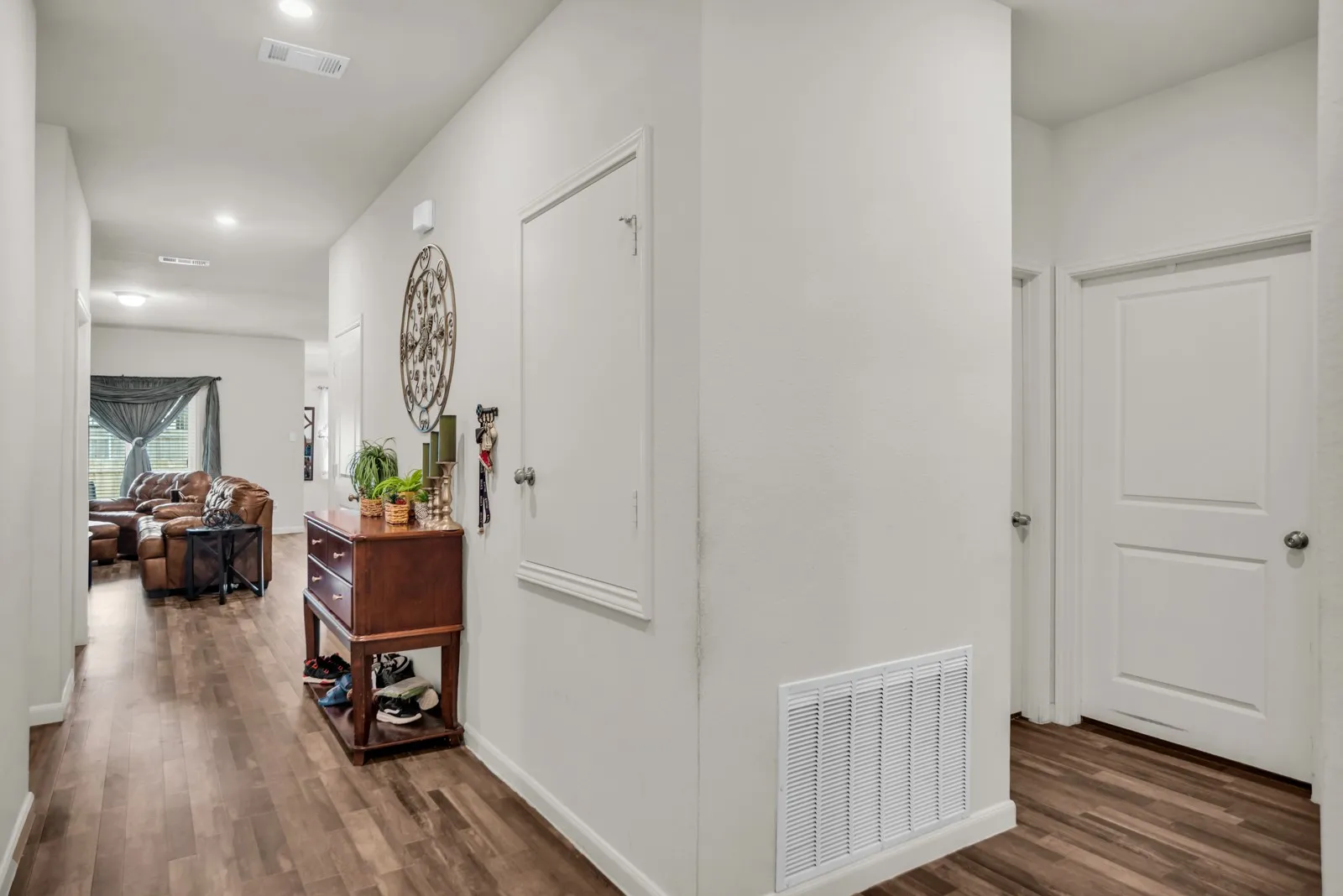 Hallway featuring wood-finish flooring, recessed lighting, and crisp white walls