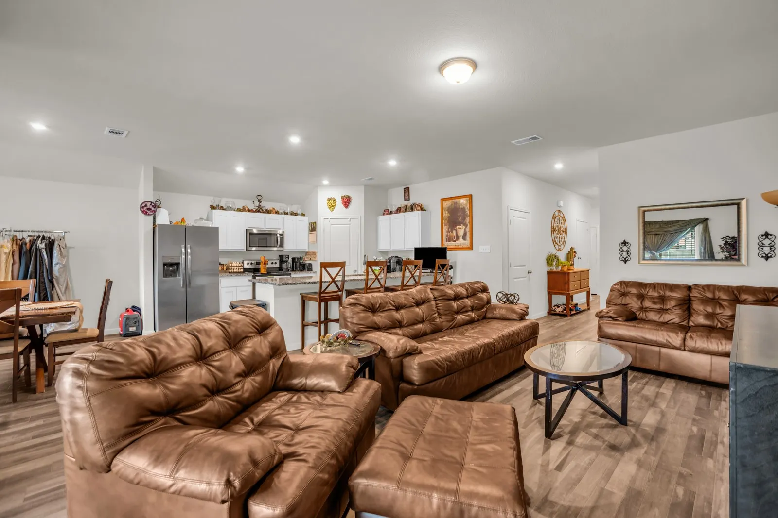 Open-concept living space featuring wood-finish flooring, recessed lighting, and a neutral color palette