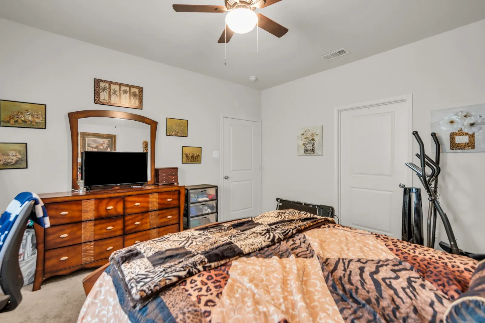 Carpeted room featuring a ceiling fan with integrated lighting, white walls, and two panel doors