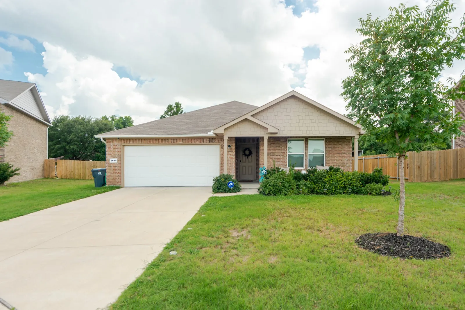 Brick exterior featuring a covered entry and an attached garage