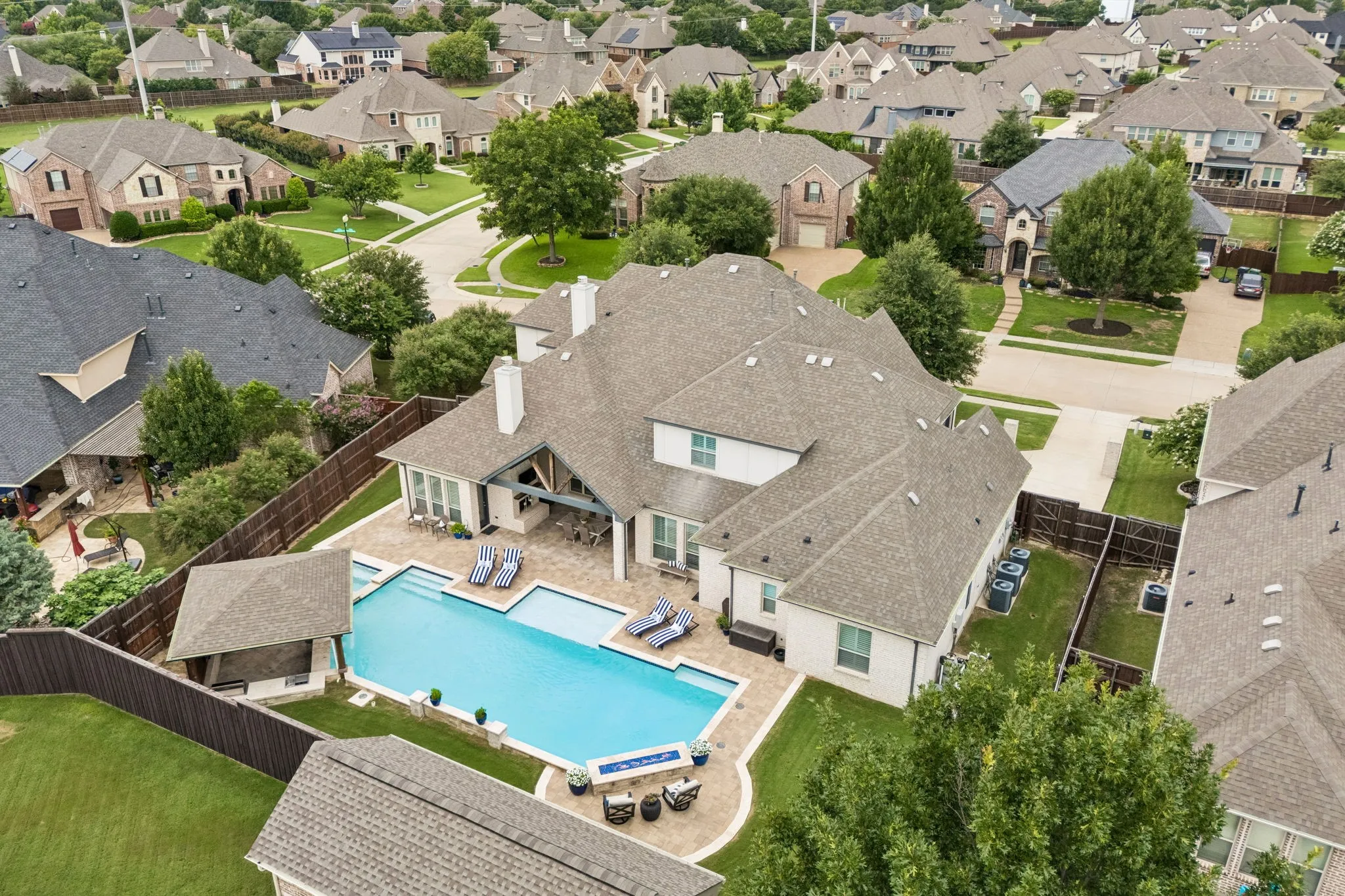 Large covered patio with wood burning fireplace and fan complete this Entertainer's Dream yard!