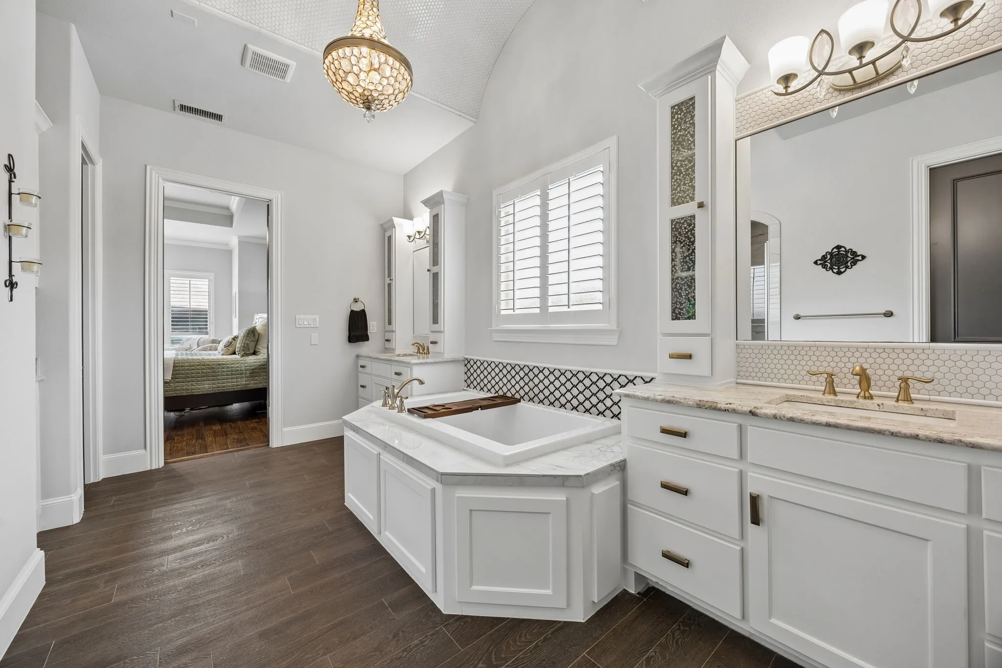 Separate Vanities with extra storage, wood tile flooring, oversized decked tub, granite countertops, 2 closets, separate shower