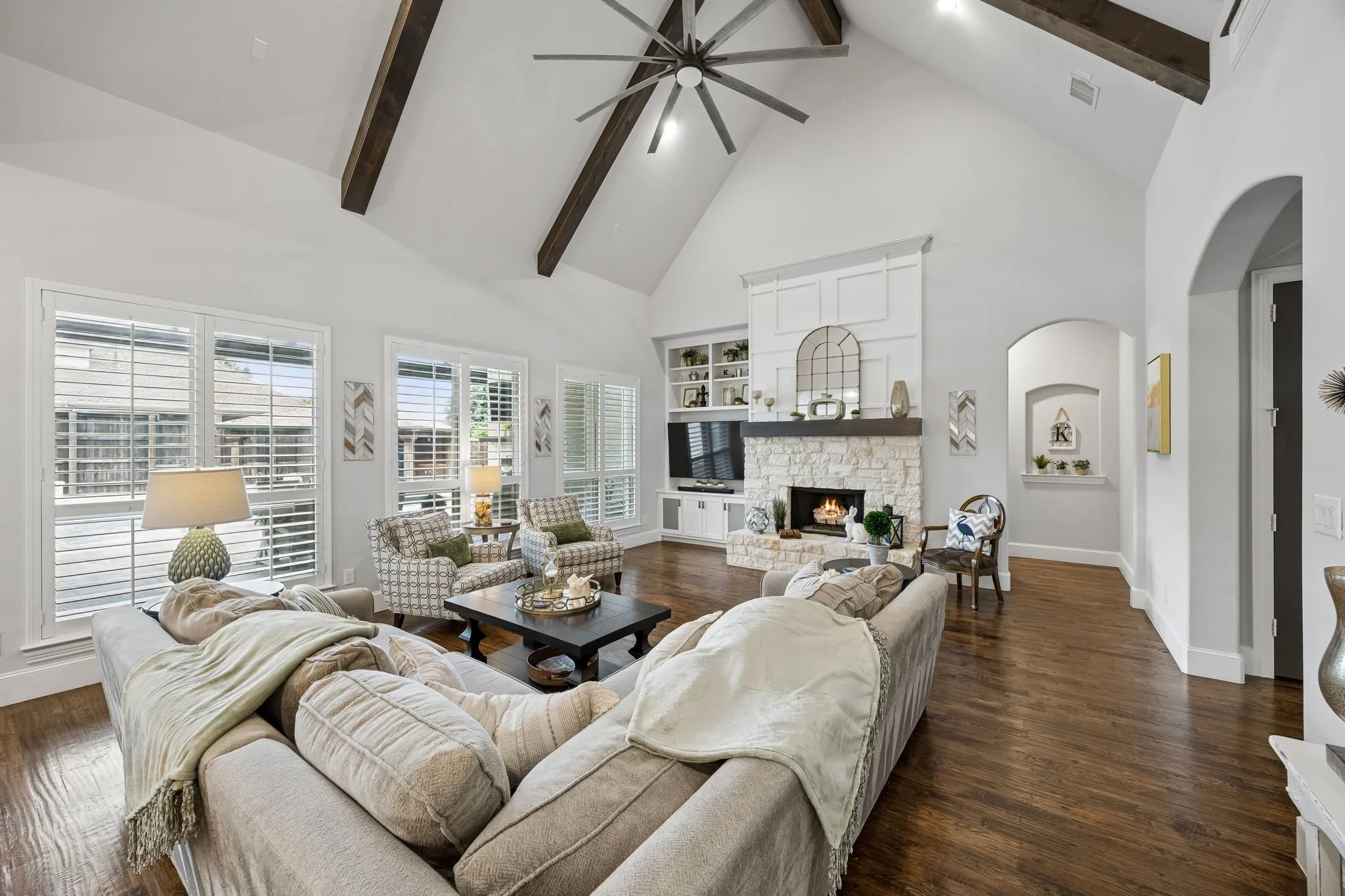 Living room is at back of house with lovely views of the backyard dream space.  Cathedral ceiling and stone fireplace.