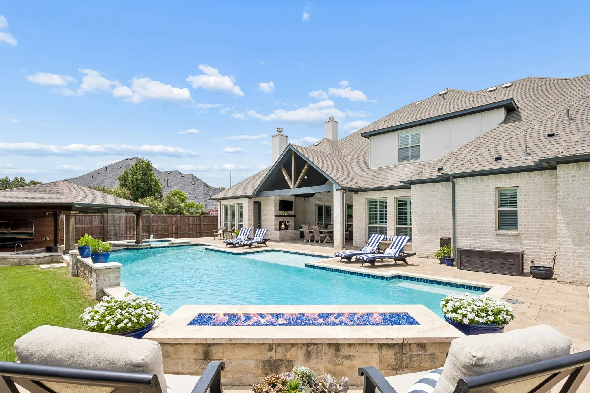 Spectacular backyard with a pool designed specifically for laps.  Heated Pool and Spa, add a custom Firepit and a sunken covered outdoor kitchen with built in Pellet Grill, Bar Sink and outdoor fridge.  5 seat swim up bar is a crowd pleaser.