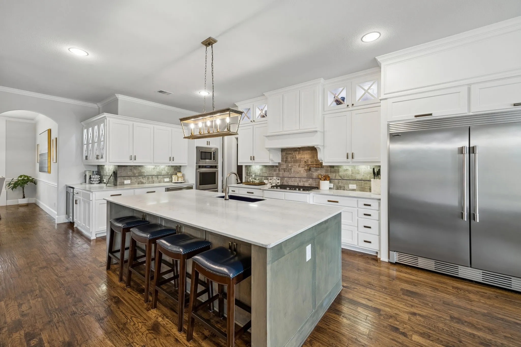 A Chef's Dream Kitchen.  From the Double Built in Refrigerator, Gas Cooktop with convenient Pot Filler, Double Convection Ovens, Microwave and a Warming Drawer.  Wrap around counter features lighted cabinets and a Wine Cooler built in.  First pantry is across from the wrap around.  Second pantry behind the double ovens!
