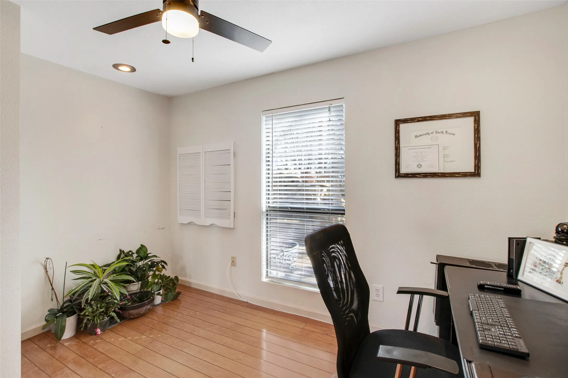 Light wood-finish flooring with a ceiling fan, recessed lighting, and a window with blinds