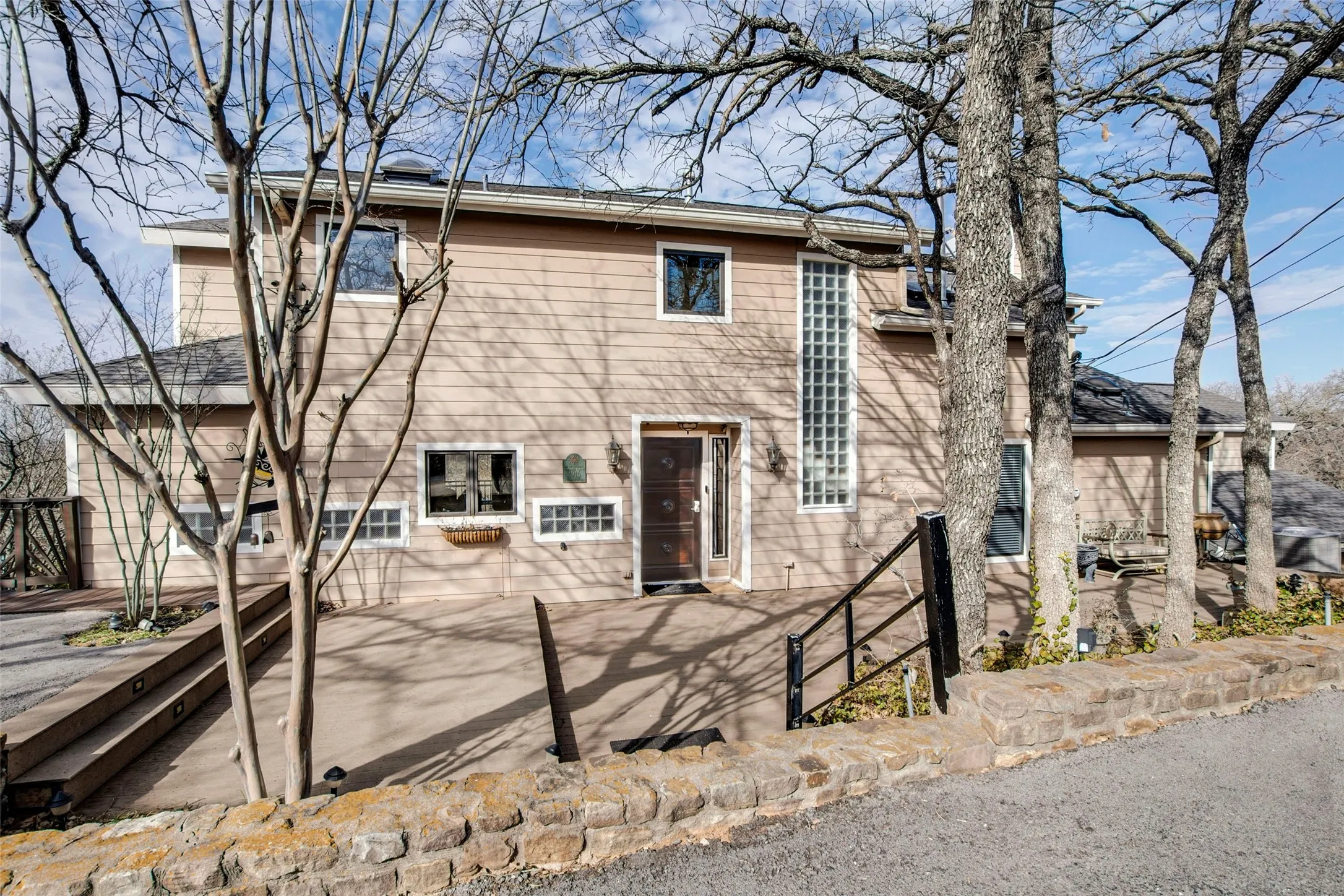 Two-story residence featuring light-colored siding and multiple windows