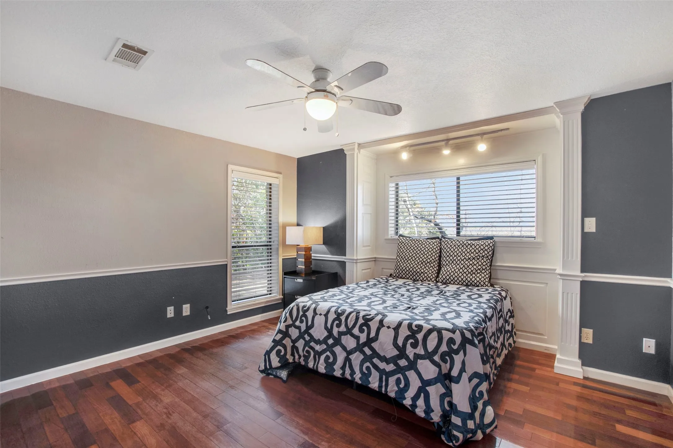 Hardwood-finish flooring enhancing a room with a two-tone wall treatment and white crown molding