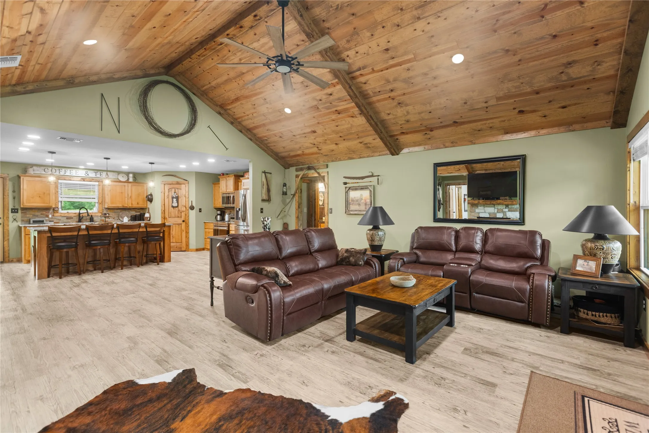 Vaulted wood-plank ceiling with ceiling fan and recessed lighting