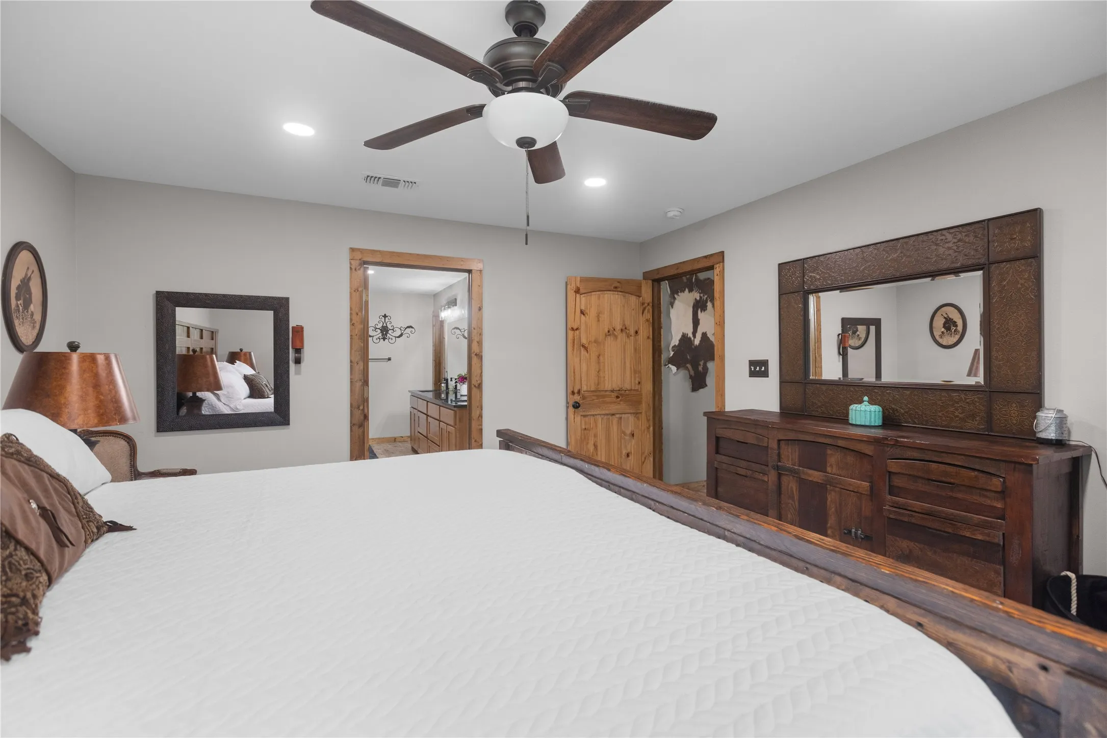 Neutral wall color complemented by natural wood door frames and an overhead ceiling fan with lighting