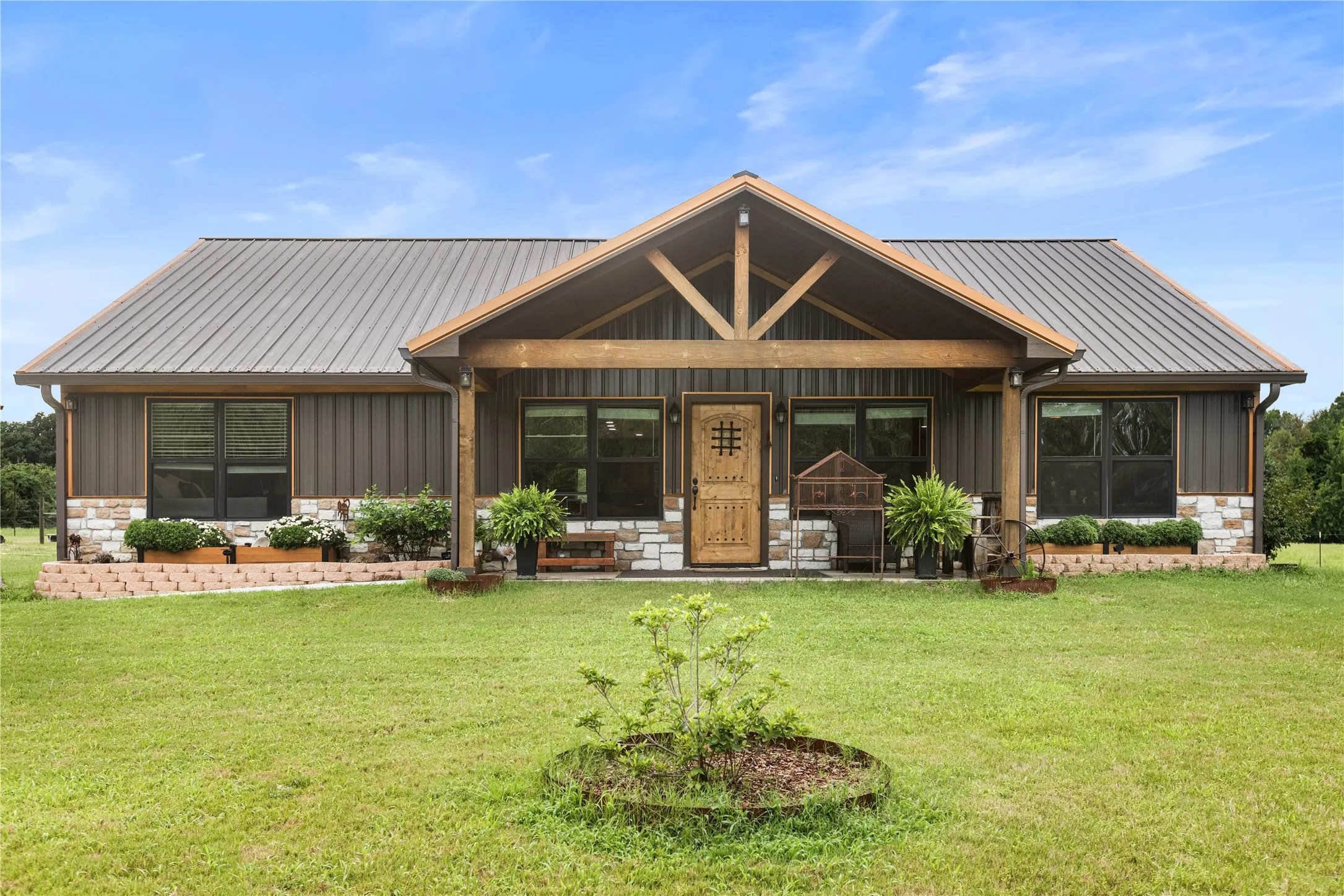 Wood-paneled siding exterior featuring a metal roof and stone foundation accents